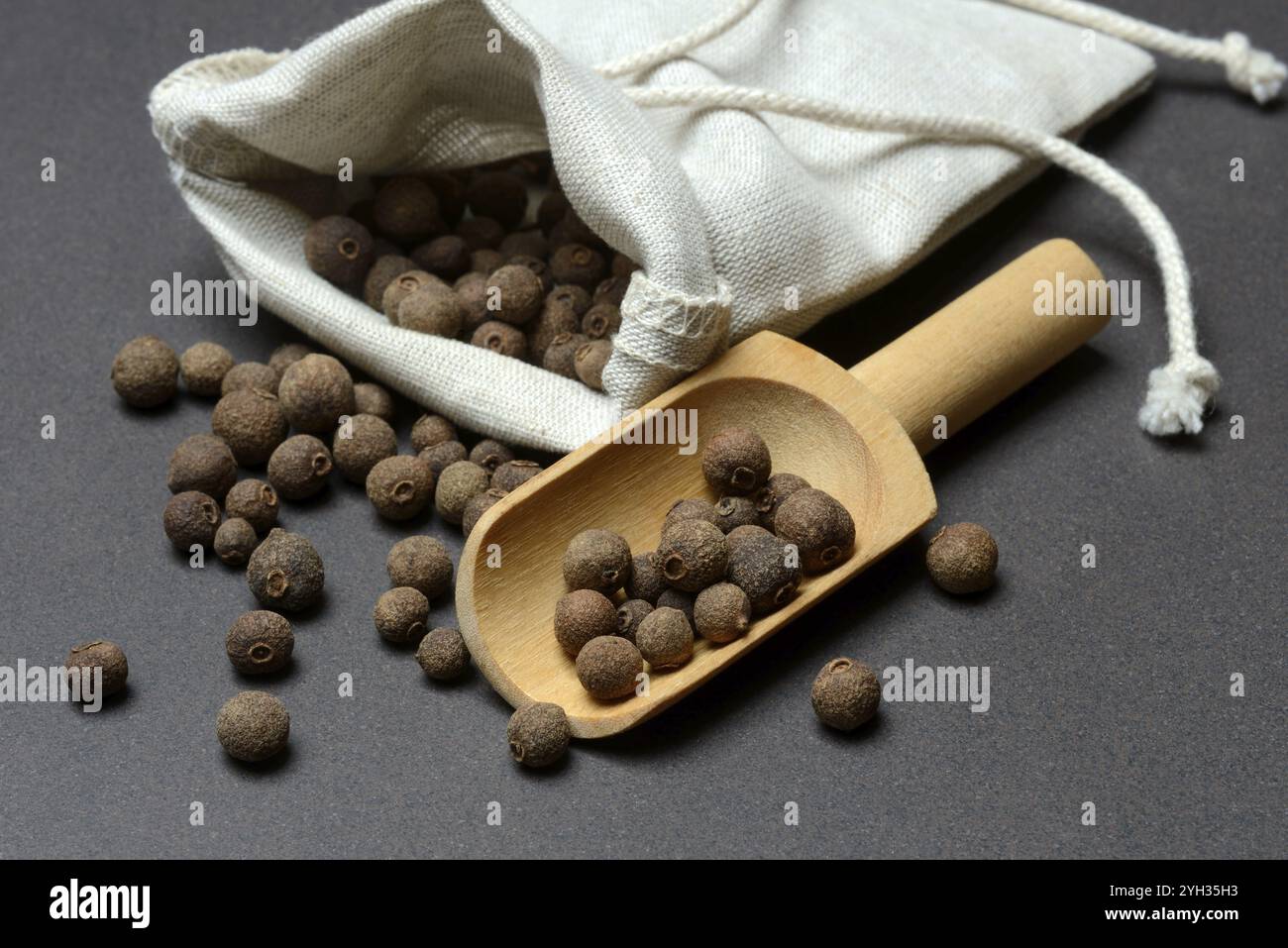 Pepe, grani di pepe in pala di legno, Pimenta dioica Foto Stock