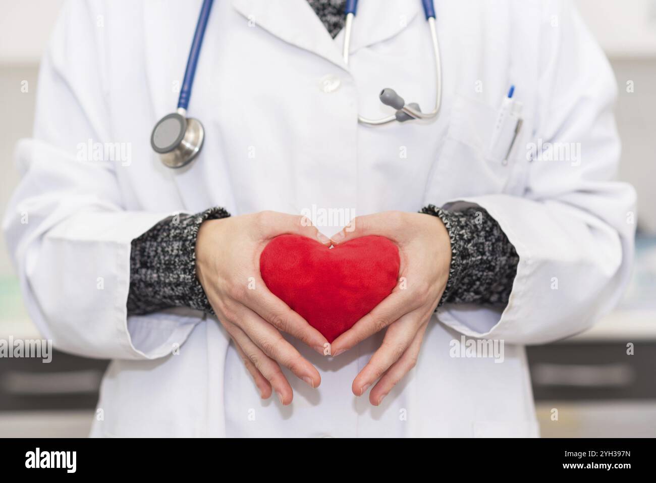 Medico tenendo un cuore rosso forma Foto Stock