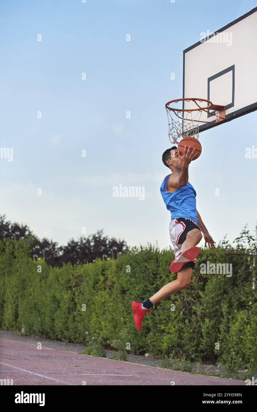 Il basket street player facendo una slam dunk Foto Stock