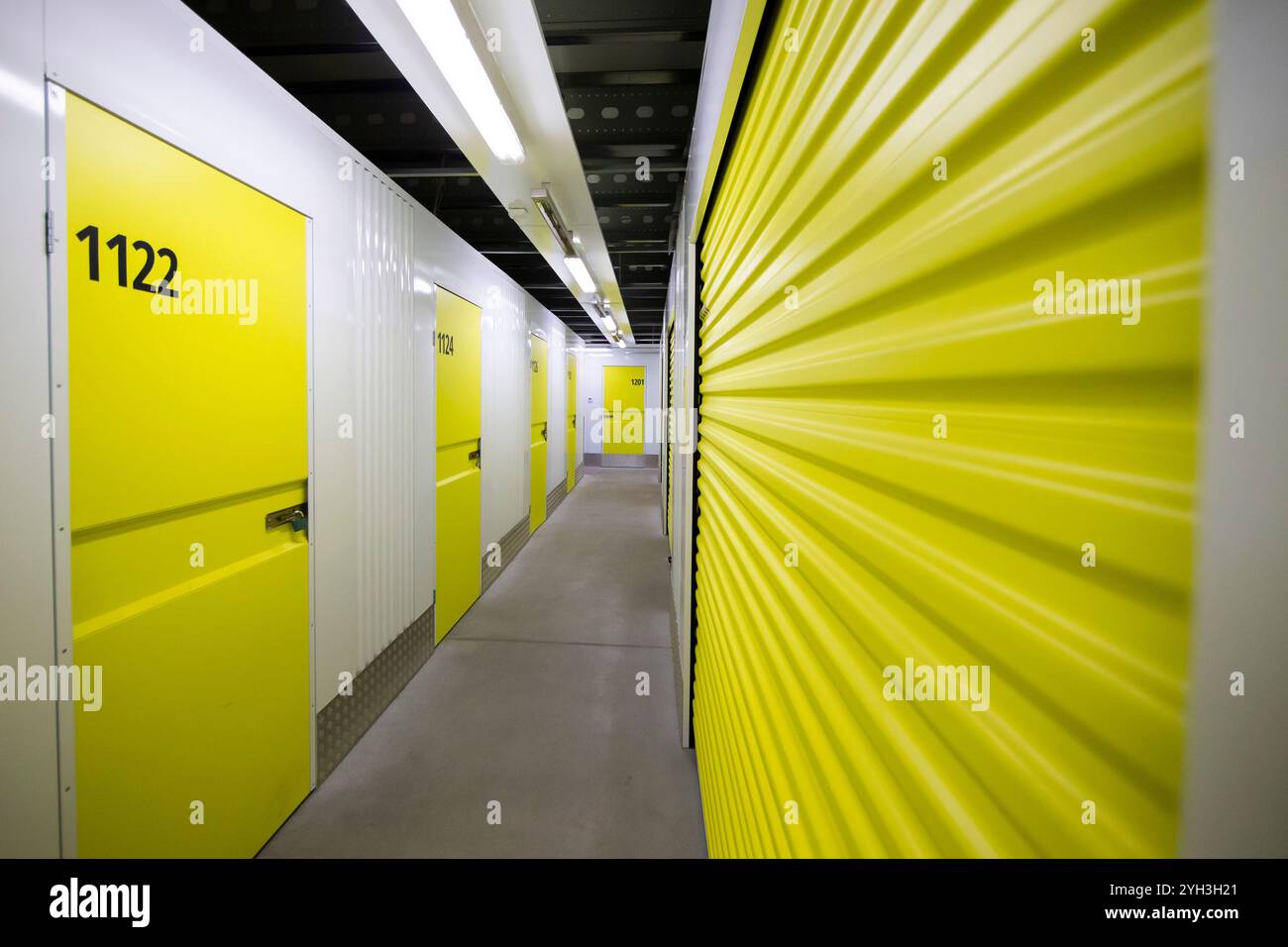 Armadietti di stoccaggio gialli numerati in una struttura ben illuminata, che offrono soluzioni di stoccaggio sicure e organizzate. Foto Stock