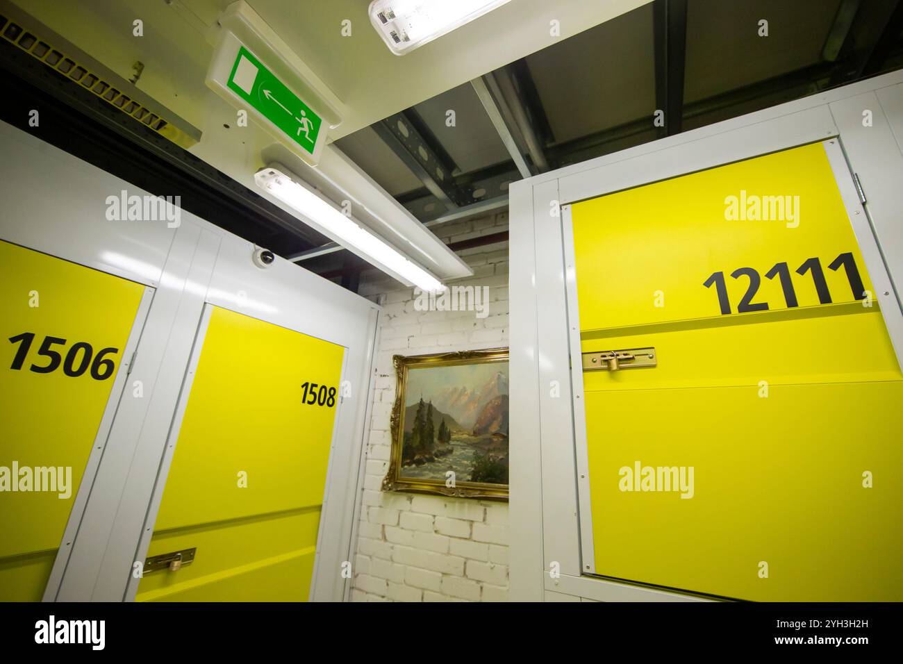 Armadietti di stoccaggio gialli numerati in una struttura ben illuminata, che offrono soluzioni di stoccaggio sicure e organizzate. Foto Stock