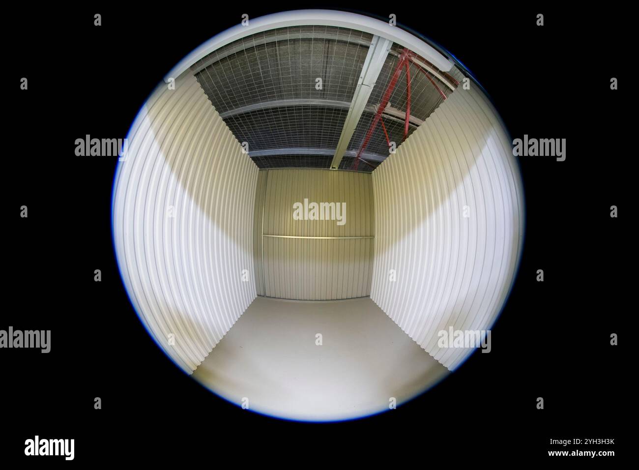 Vista fisheye di un'unità di stoccaggio vuota con pareti metalliche e soffitto in una struttura. Foto Stock