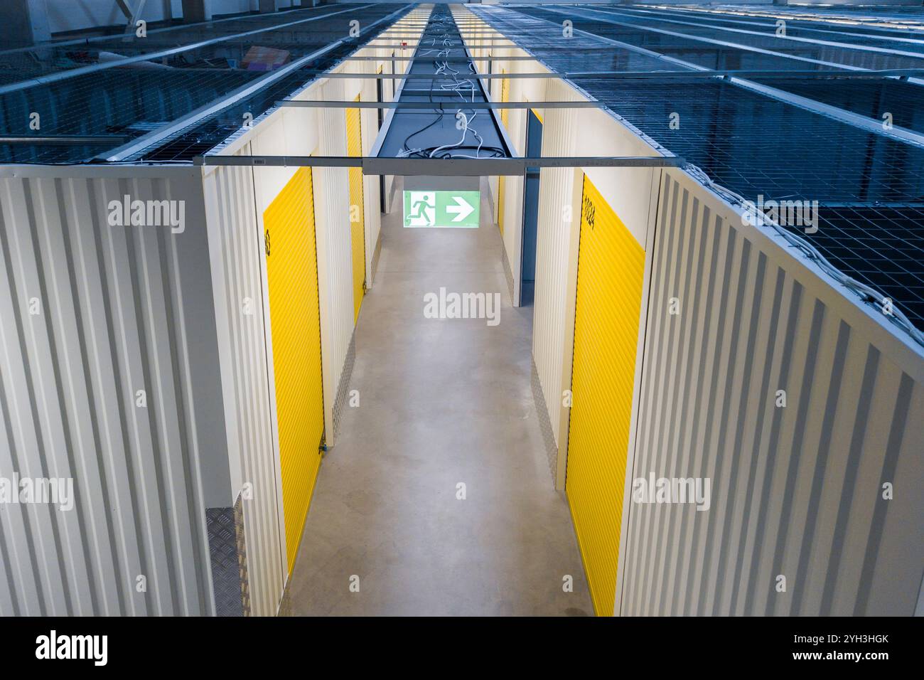 Vista dall'alto delle unità di stoccaggio in metallo organizzate con pareti a griglia e marcatori gialli in una struttura. Foto Stock