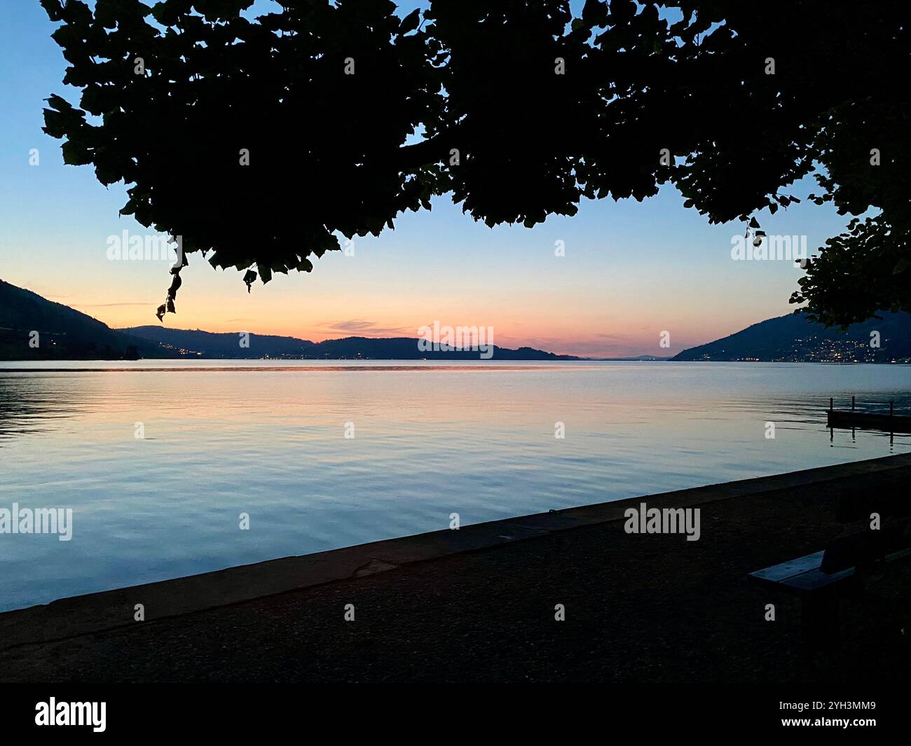 Tranquillo tramonto sul lago con vista sulle montagne - Immagine stock catturata con smartphone