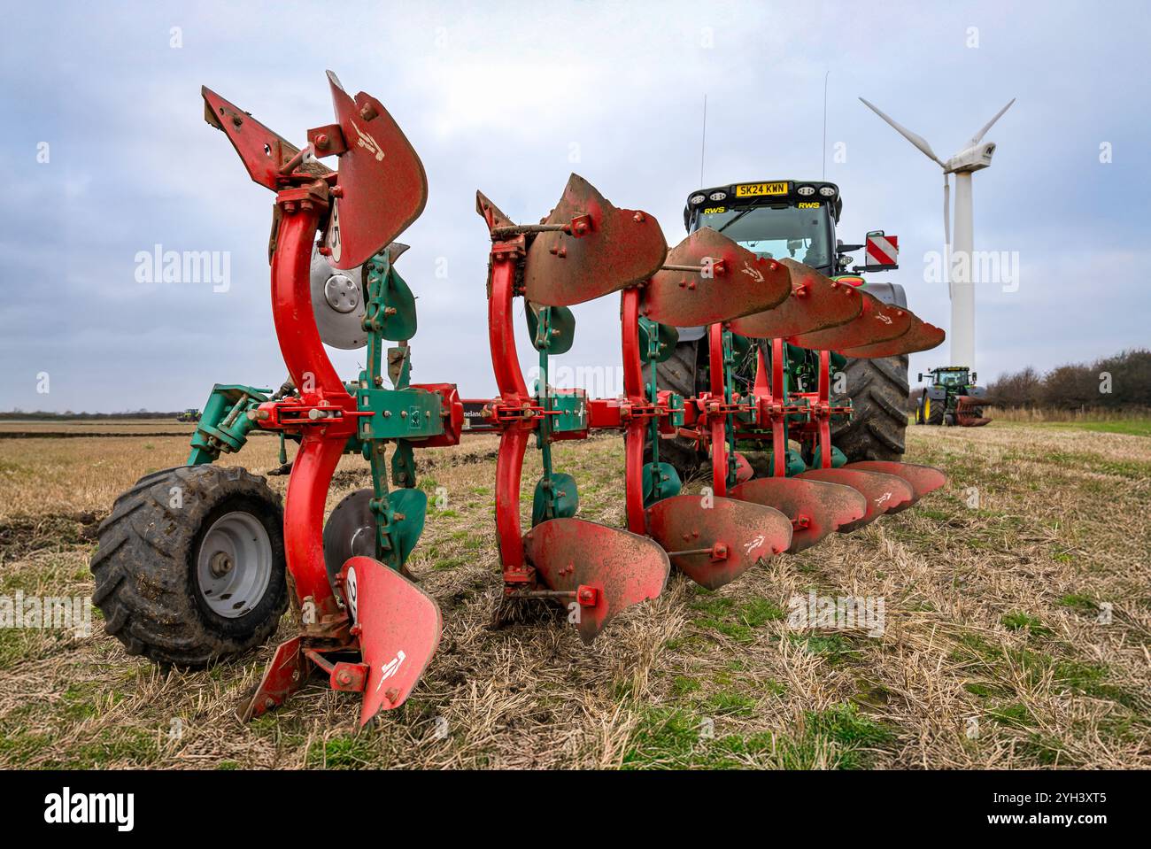Trattore agricolo John Deere di grandi dimensioni nel campo di stoppia, East Lothian, Scozia, Regno Unito Foto Stock