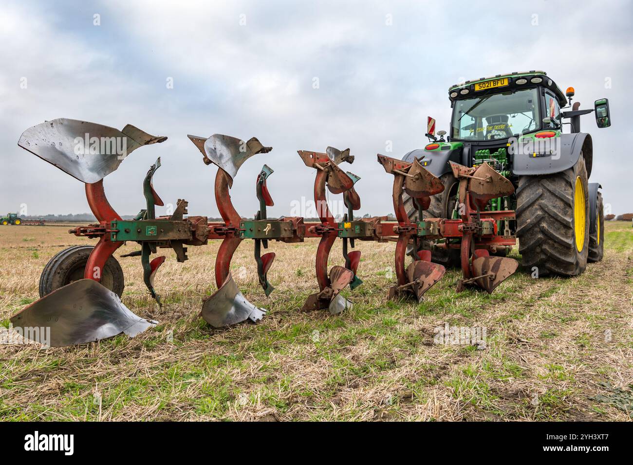 Trattore agricolo John Deere di grandi dimensioni nel campo di stoppia, East Lothian, Scozia, Regno Unito Foto Stock