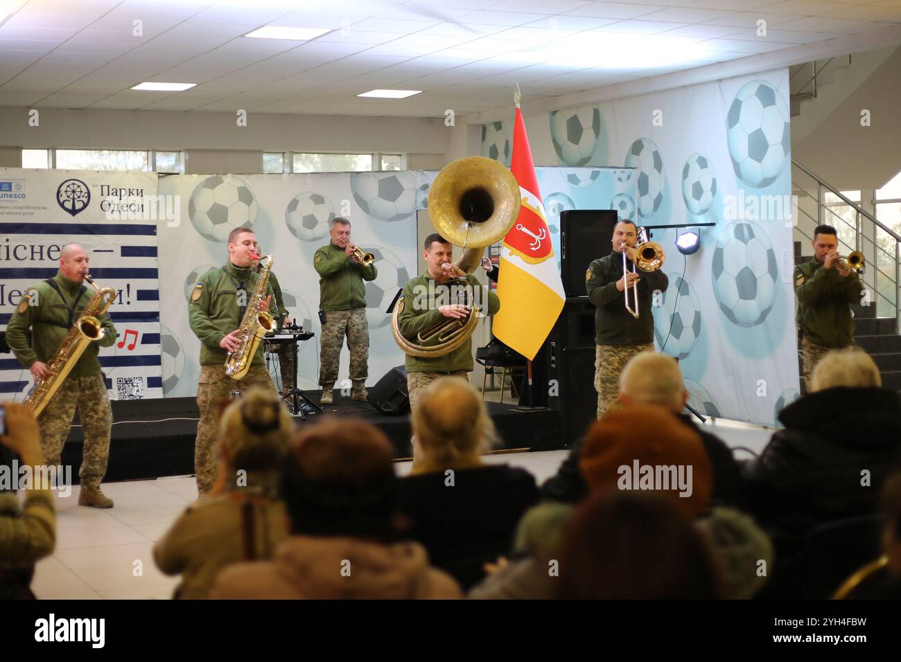 Odessa, Ucraina. 9 novembre 2024. Gli spettatori guardano l'esibizione di musicisti dell'orchestra da concerto dell'Accademia militare di Odessa, Brass Band 'Good Evening' nella hall dello stadio Chornomorets. Esibizione di musicisti dell'orchestra da concerto dell'Accademia militare di Odessa, Brass Band "Good Evening" nella hall dello stadio Chornomorets. L'obiettivo è sostenere il morale della popolazione durante l'aggressione militare della Federazione Russa. Credito: SOPA Images Limited/Alamy Live News Foto Stock