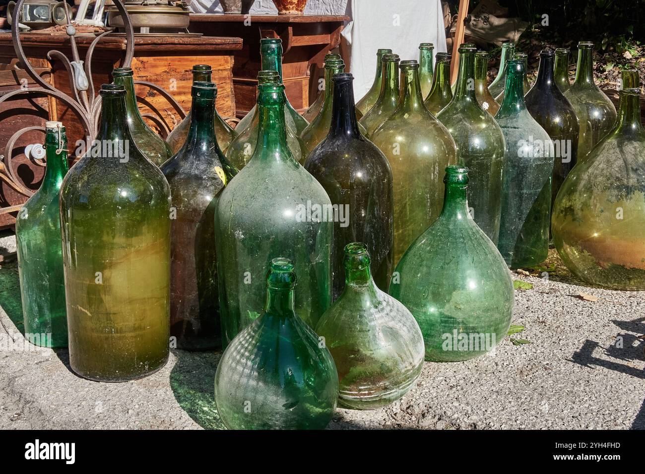 Trevi, Italia - 11 03 2024 - vecchi demijohns in vetro soffiato per la conservazione di vino e olio, venduti in un mercato delle pulci in Umbria Foto Stock