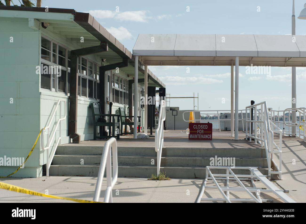 Lato dell'edificio delle linee principali di Gulfport, Florida, Stati Uniti. Scala storica del casinò Gulfport e nastro giallo di avvertimento dopo l'uragano Milton. Spiaggia erosi profonda Foto Stock