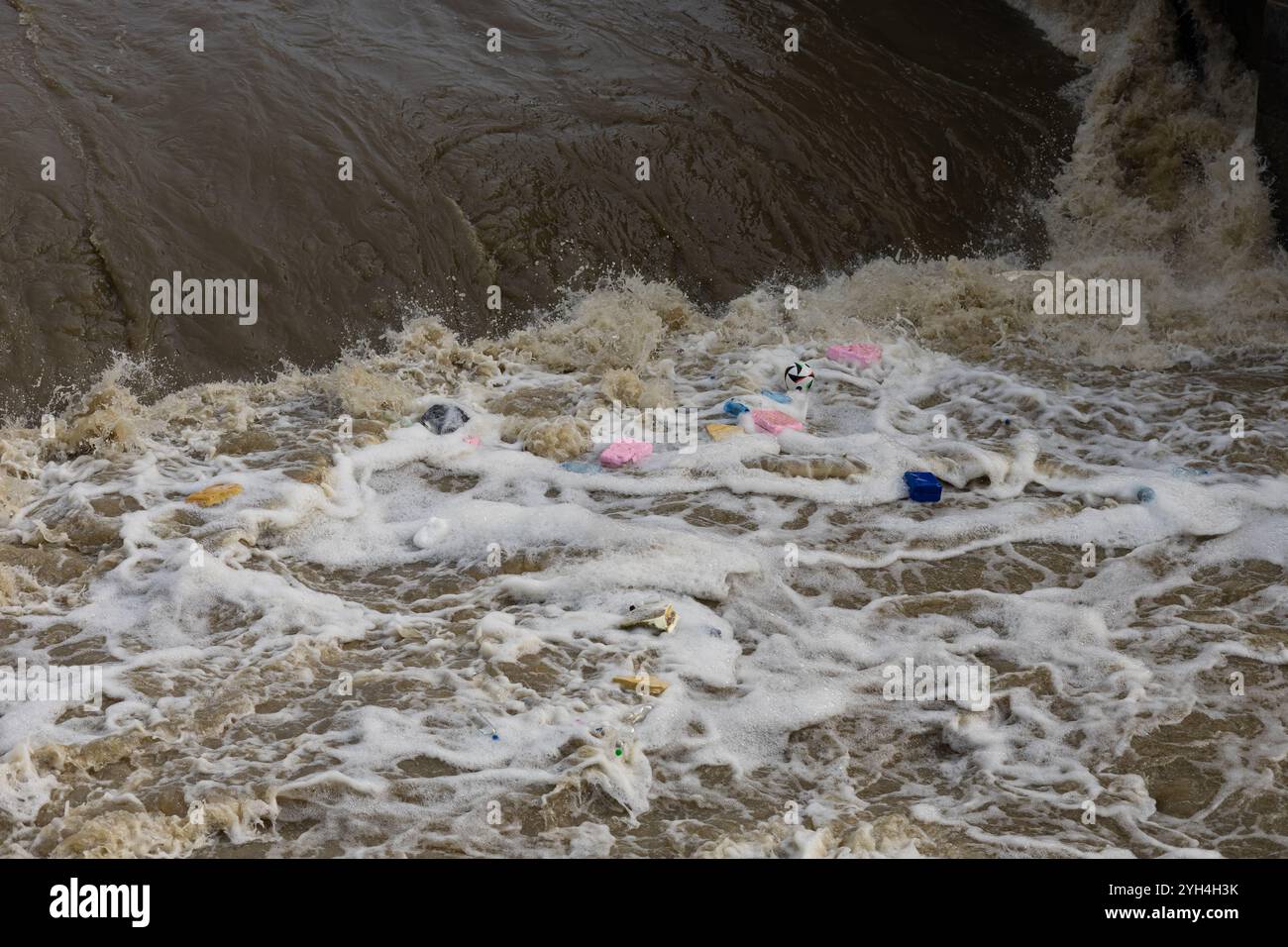 Acqua di fiume inquinata con detriti plastici galleggianti, bottiglie e materiali di scarto. Danni ambientali e impatto delle attività umane sulla natura Foto Stock