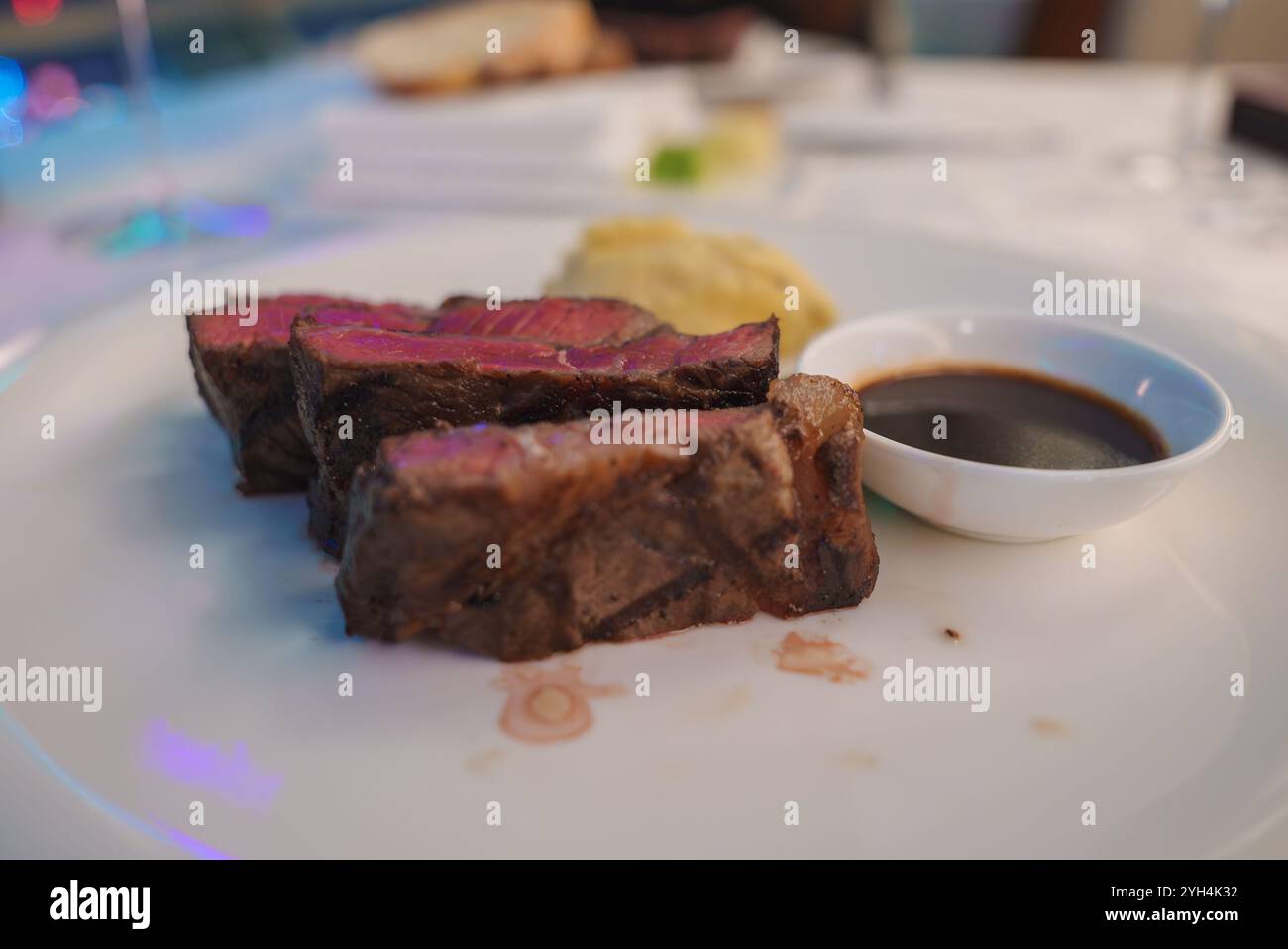 Primo piano di bistecca media rara con salsa da immersione sul piatto Foto Stock