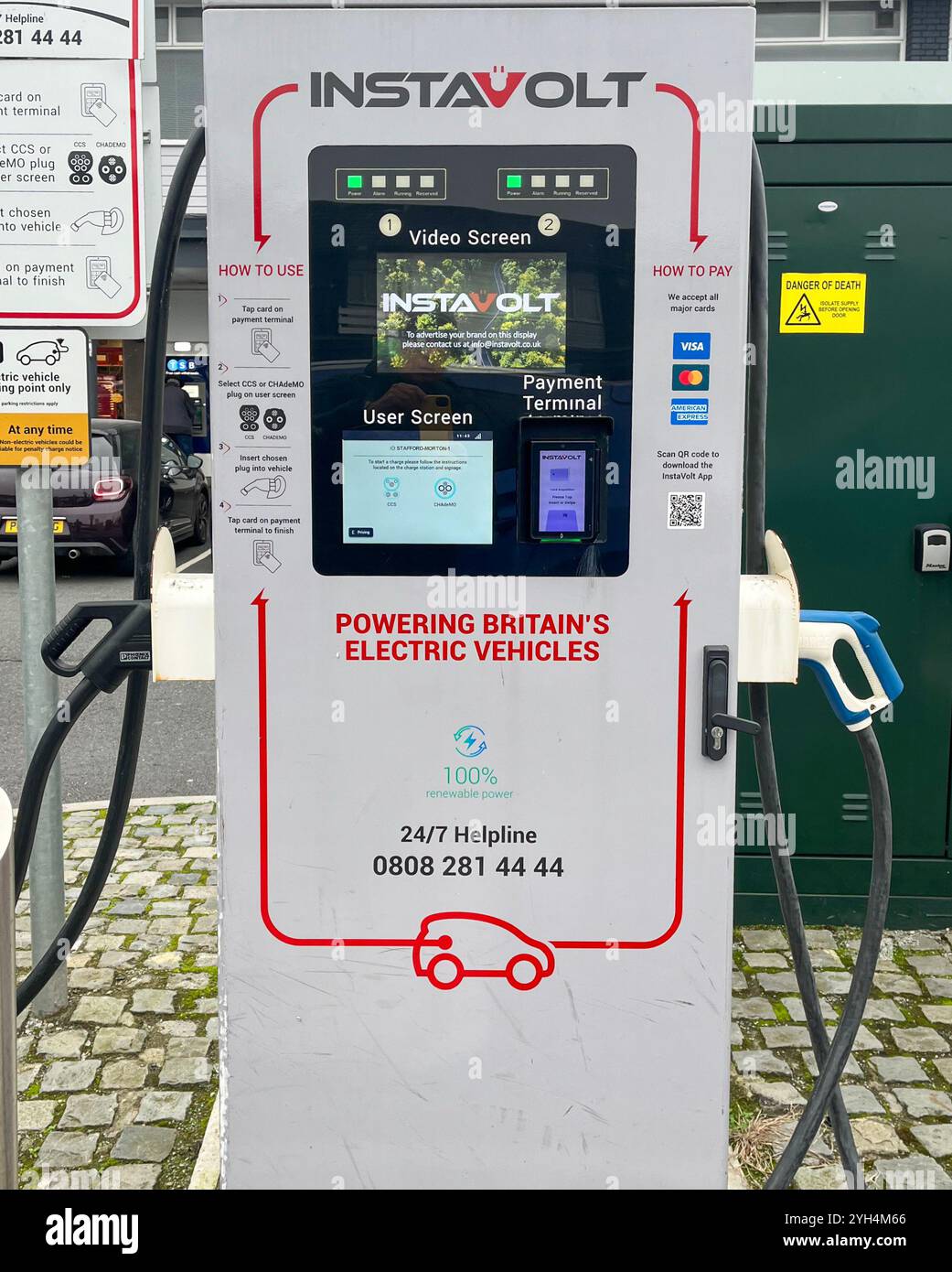 Un caricabatterie per auto elettriche in un parcheggio pubblico - Immagine stock catturata con smartphone