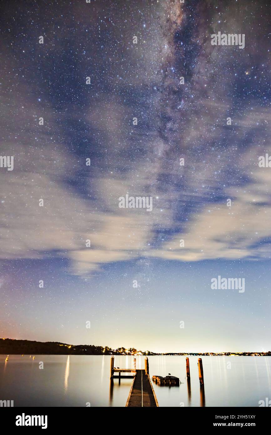 Via Lattea dietro nuvole sfocate sul Lago Macquarie in Australia - osservazione delle stelle del cielo notturno. Foto Stock