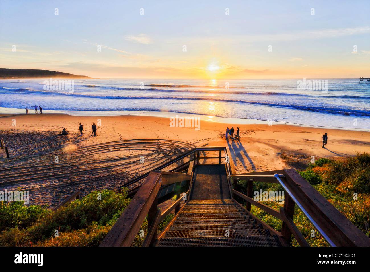 Irriconoscibile gente del posto sulla spiaggia di Middle Camp della baia di Catherine Hill sulla costa del Pacifico dell'Australia all'alba. Foto Stock