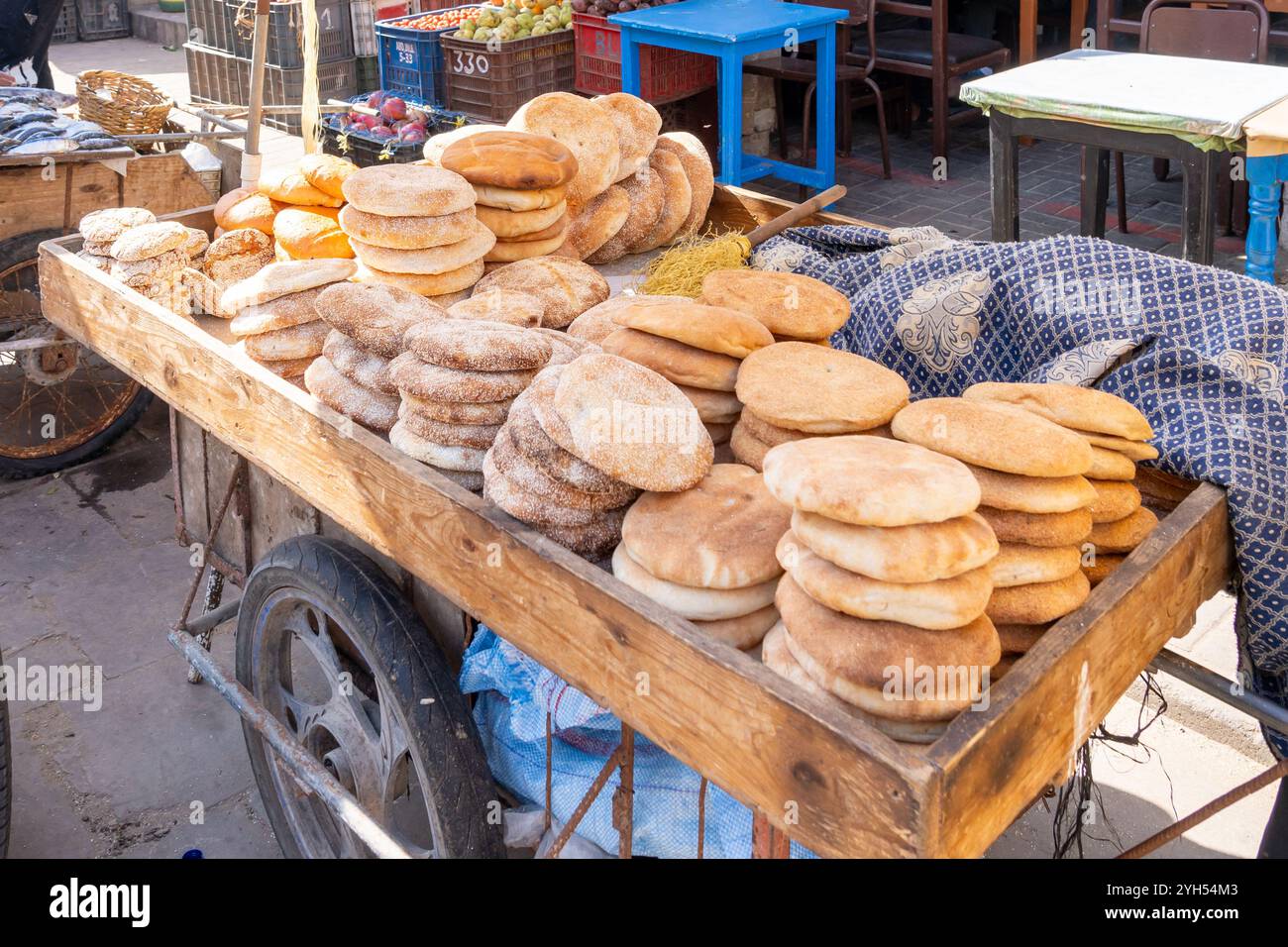 Pane tradizionale appena sfornato (Khobz) su un carrello in vendita al mattino in un tipico mercato di strada del Marocco. Foto Stock