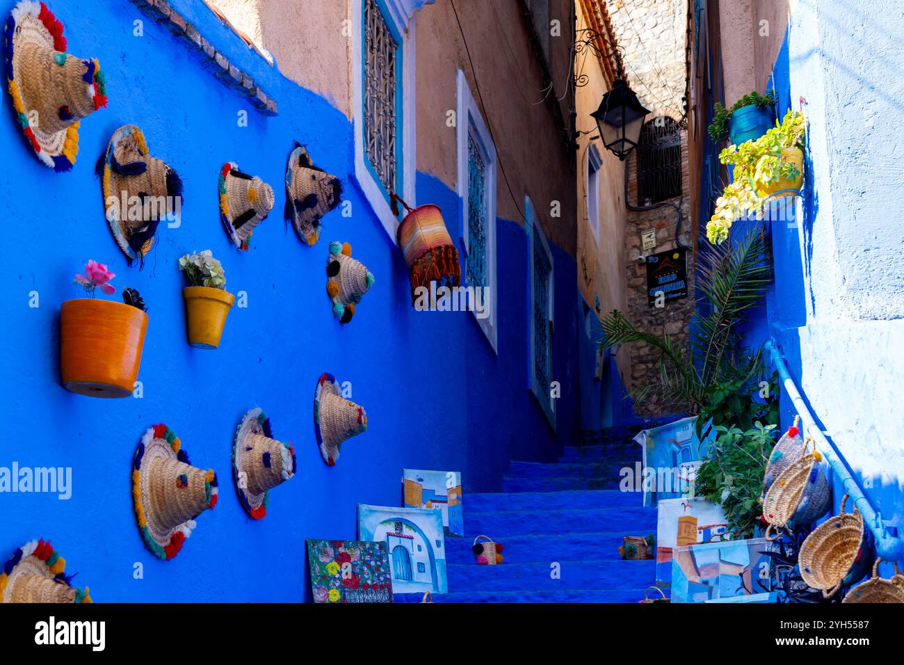 Case e strade di colore blu con souvenir turistici esposti in vendita a Chefchaouen, Marocco. Foto Stock