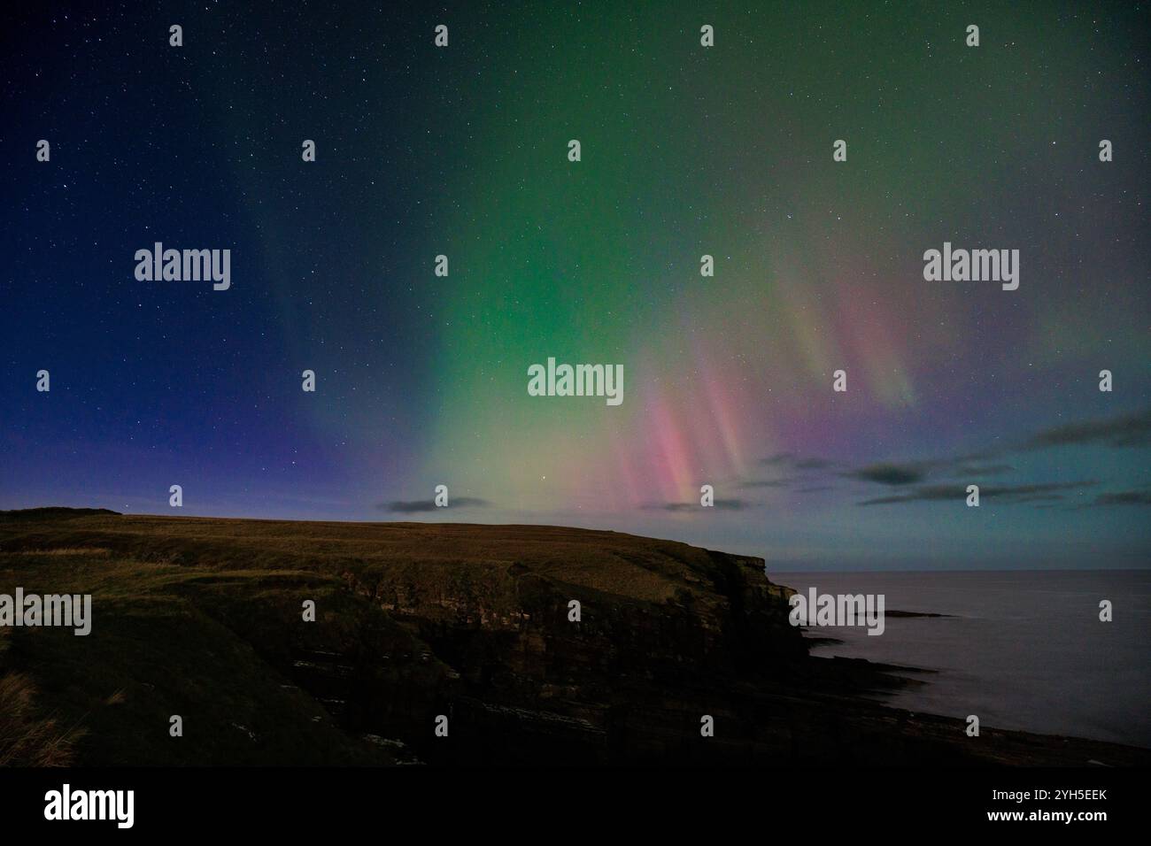 9 novembre 2024, Sandside Bay, Caithness, Scozia. Una colorata aurora boreale, o aurora boreale, illumina il cielo a Sandside Bay. Foto Stock