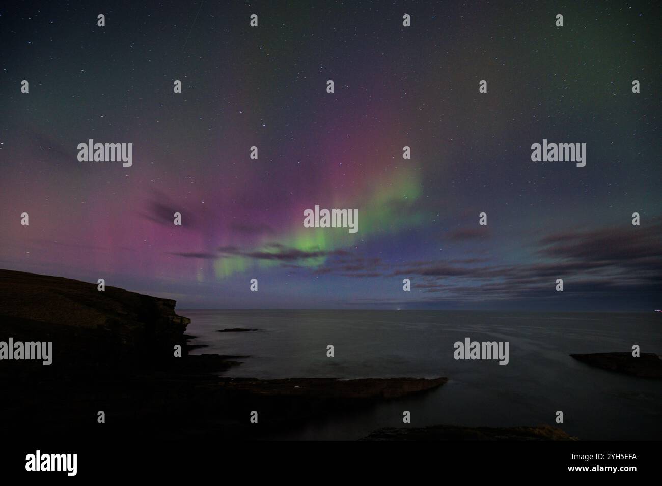 9 novembre 2024, Sandside Bay, Caithness, Scozia. Una colorata aurora boreale, o aurora boreale, illumina il cielo a Sandside Bay. Foto Stock