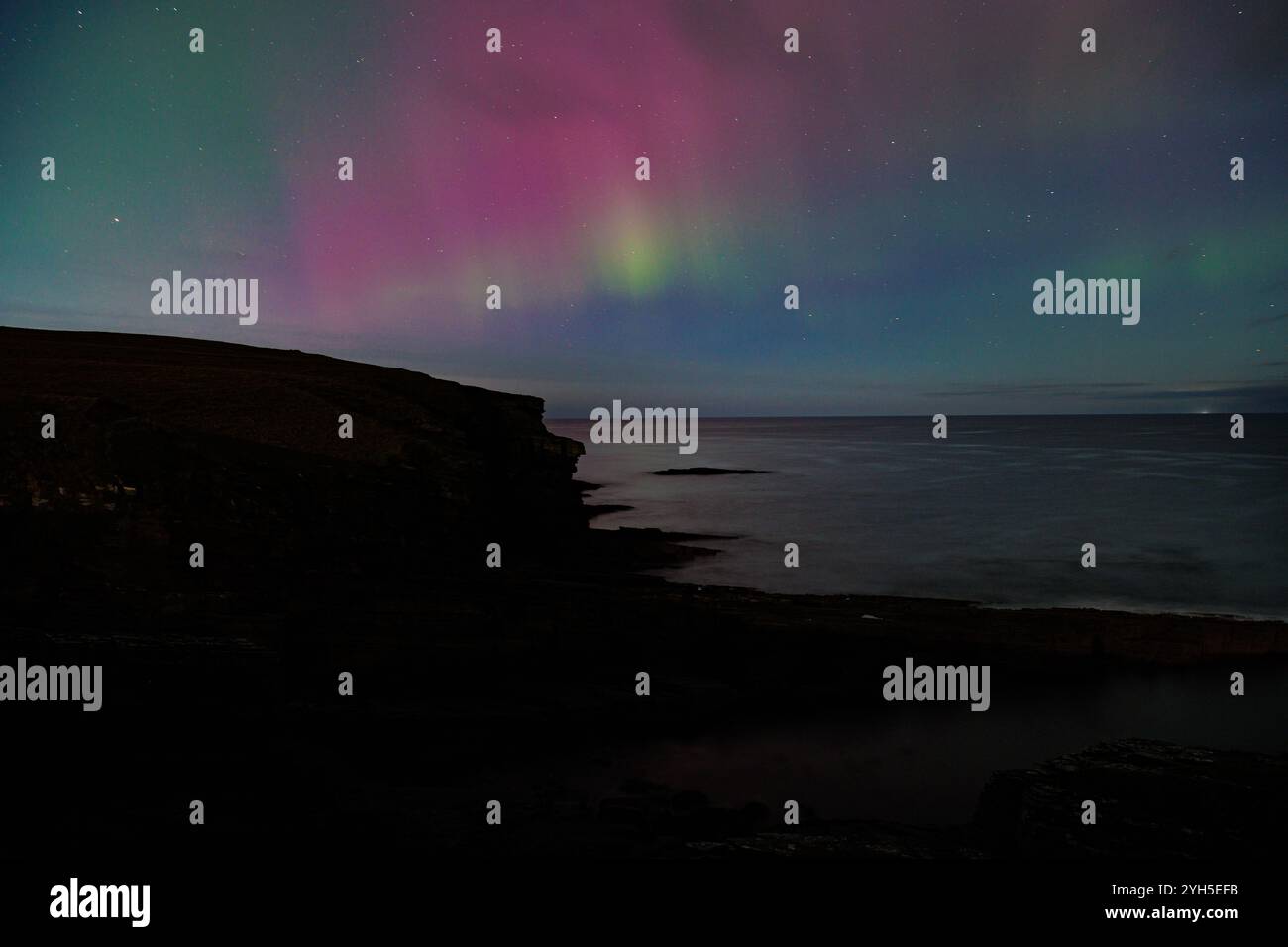 9 novembre 2024, Sandside Bay, Caithness, Scozia. Una colorata aurora boreale, o aurora boreale, illumina il cielo a Sandside Bay. Foto Stock