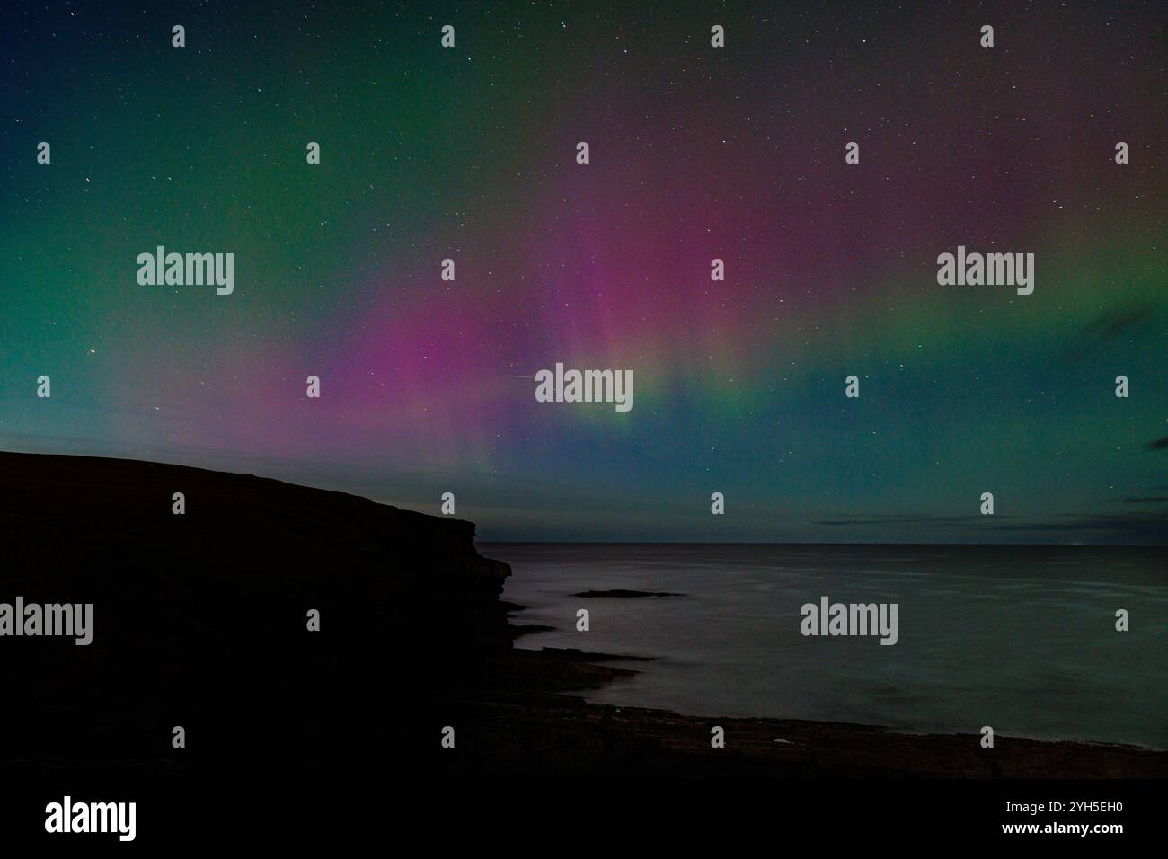 9 novembre 2024, Sandside Bay, Caithness, Scozia. Una colorata aurora boreale, o aurora boreale, illumina il cielo a Sandside Bay. Foto Stock