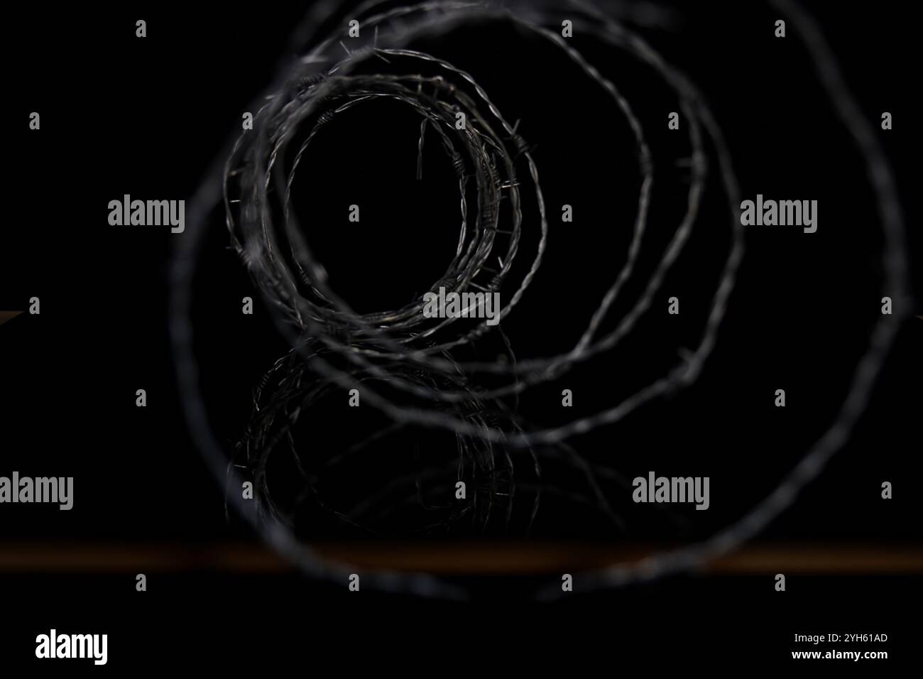 Filo a fisarmonica a spirale con punte. Scherma di protezione militare. Foto Stock