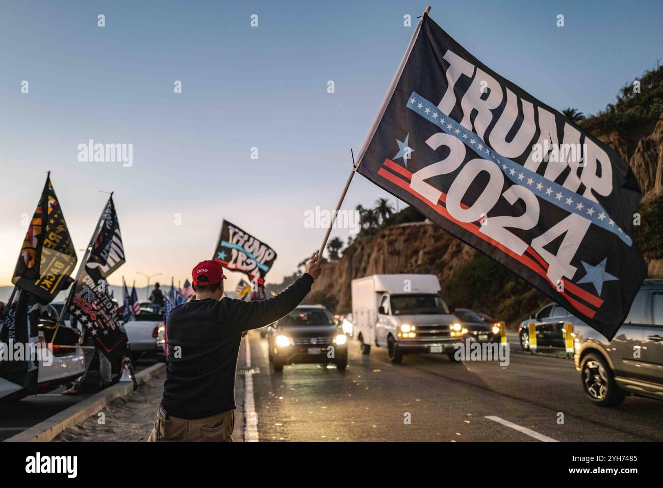 Una grande ed entusiasta folla di sostenitori di Trump si riunisce sulla spiaggia di Santa Monica al tramonto, sventolando bandiere americane e festeggiando i risultati elettorali. Il cielo è dipinto con calde tonalità arancio e rosa, che aggiungono un'atmosfera festosa. Santa Monica Beach ha visto un raduno di sostenitori di Trump celebrare la sua vittoria prevista nelle elezioni presidenziali degli Stati Uniti del 2024. L'evento attirò una folla entusiasta, mentre la gente sventolava bandiere, cantava slogan e condivideva l'entusiasmo. Organizzata spontaneamente attraverso i social media, la celebrazione ha visto un mix di famiglie, giovani sostenitori e da tempo indietro Foto Stock