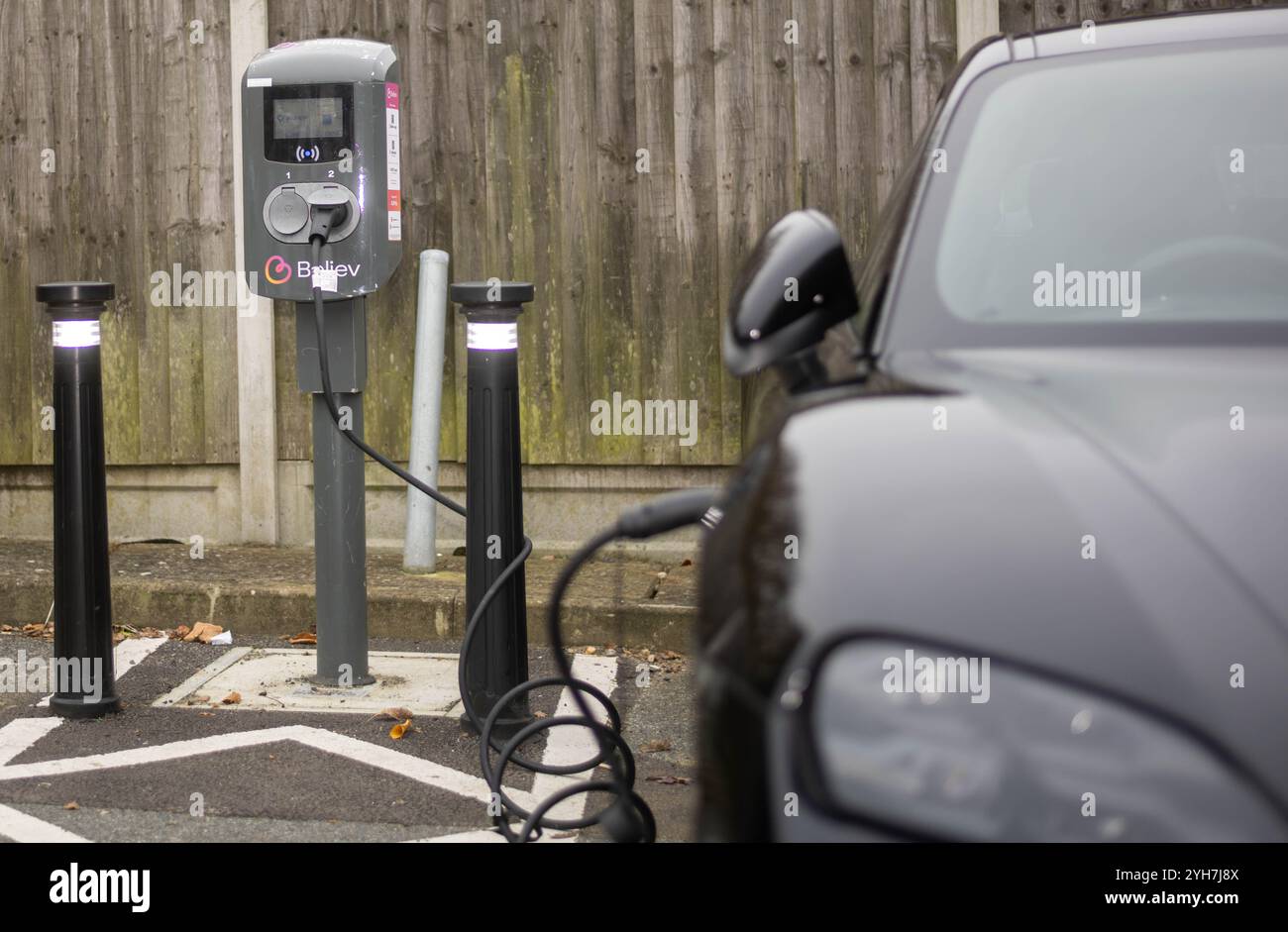 Veicoli elettrici che si ricaricano presso un punto di ricarica pubblico in un parcheggio comunale, Brentwood Essex Foto Stock