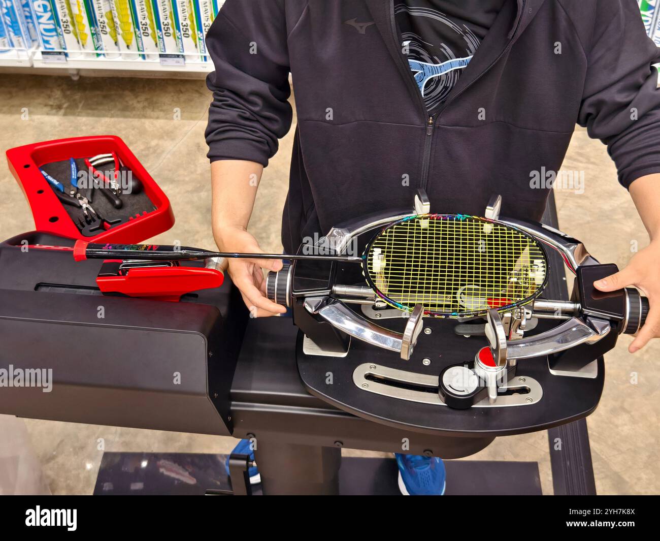 Indossa una racchetta da badminton su una macchina per stringere a racchetta. Foto Stock