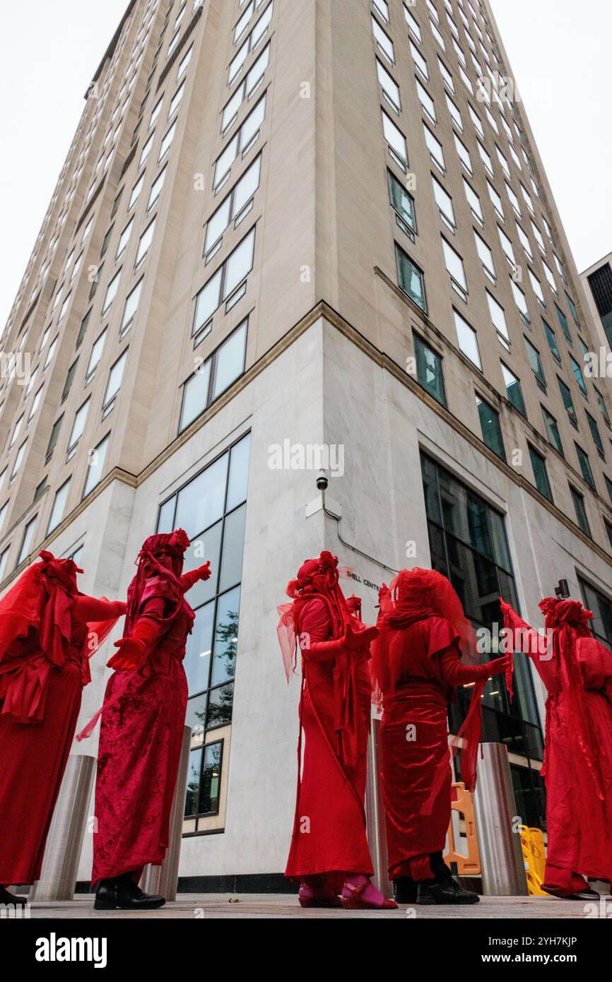 Londra, Regno Unito. 9 novembre 2024. La Red Rebel Brigade di Extinction Rebellion, un gruppo artistico di attivisti performativi creato come risposta alla crisi ambientale globale, indica al Centro Shell durante una protesta per ricordare gli Ogoni Nine nel 29° anniversario delle loro uccisioni e per evidenziare il record di inquinamento ambientale di Shell. Crediti: Mark Kerrison/Alamy Live News Foto Stock