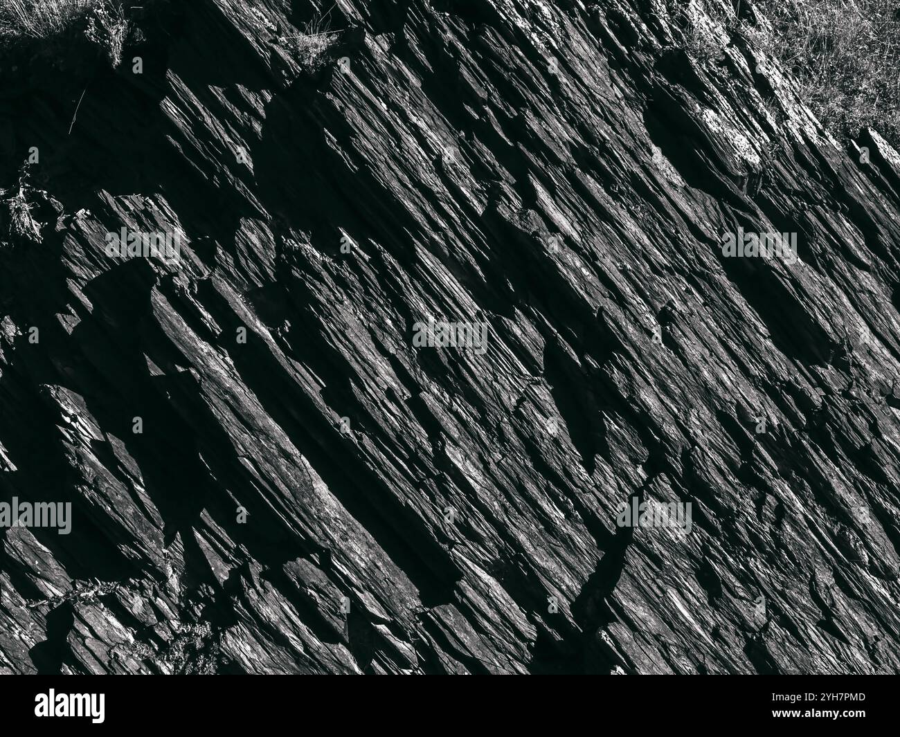 Splendido sfondo grigio scuro con superficie in pietra, stile bianco e nero. La forte roccia rocciosa, con uno schema incrinato. La superficie frastagliata della grande r Foto Stock