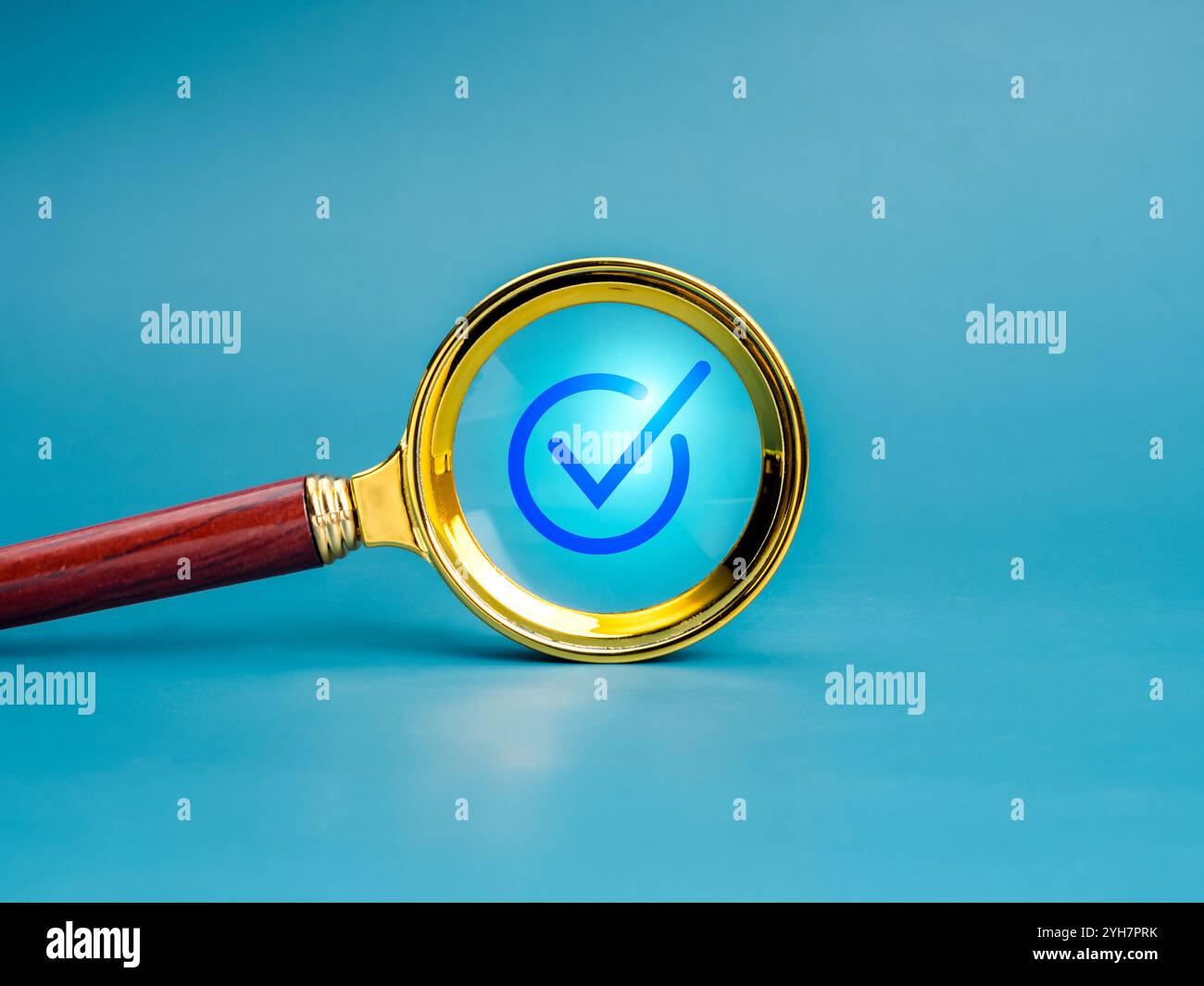 Icona con segno di spunta blu messa a fuoco con lente d'ingrandimento dorata isolata su sfondo blu, stile minimalista. Controllo qualità, approvazione aziendale, voto Foto Stock