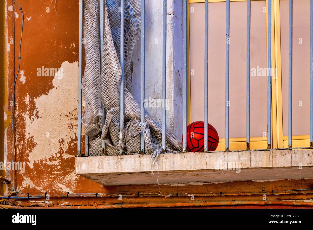 Una palla di plastica rossa su un balcone nel centro storico di Bari, Foto Stock