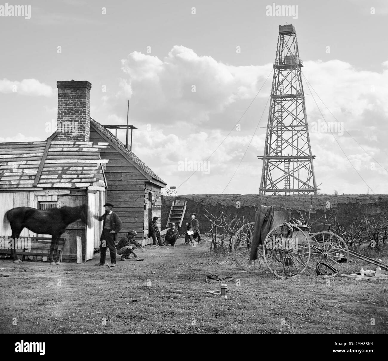Un fotografo in residenza sta con il suo cavallo. Carrello fotografico visibile a destra. Sky è stato aggiunto. Preso alla torre di segnalazione di Butler, una stazione del Signal Corps, a Point Rocks, Appomatox River, Bermuda Hundred, Virginia, 1864. un gruppo di ufficiali in uniforme è visibile sullo sfondo. Mostra un uomo afroamericano che sta accovacciando insieme al Signal Corps. Fotografia dal principale teatro di guerra orientale, l'Armata del James, giugno 1864-aprile 1865. Foto Stock