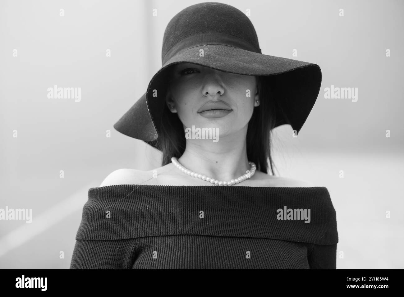 Elegante donna con cappello e perle a tesa larga. Foto Stock