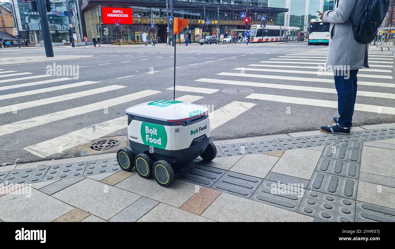 Tallinn, Estonia - 10 novembre 2024: Robot di consegna a guida autonoma Bolt Food Starship sulla trafficata strada della città. Foto Stock