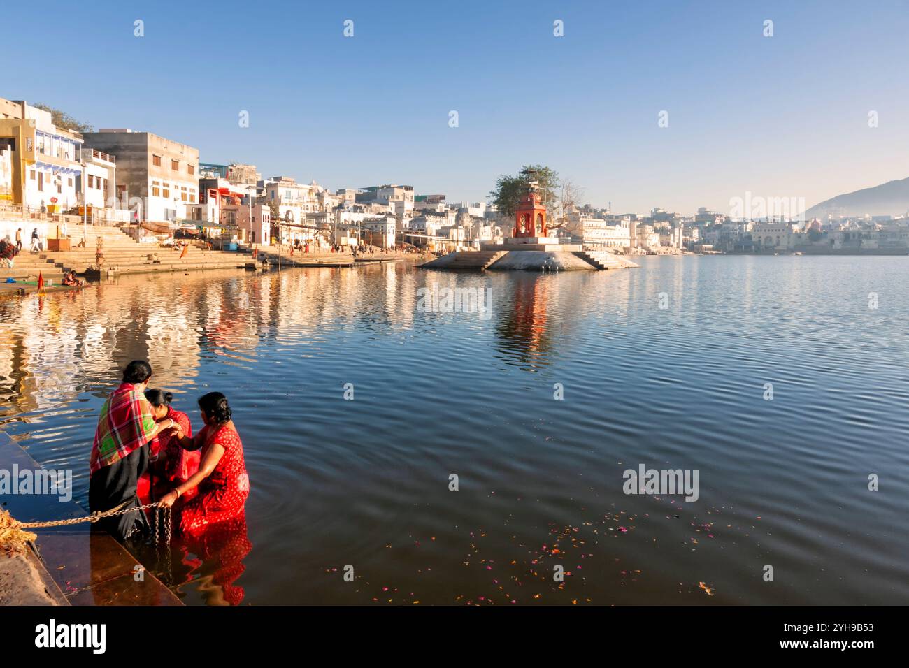 Lago Pushkar. Pellegrini indù che fanno il bagno nel sacro lago Pushkar sui ghat. Innumerevoli persone in un abbigliamento colorato si riuniscono per fare un tuffo nel lago Santo e p Foto Stock