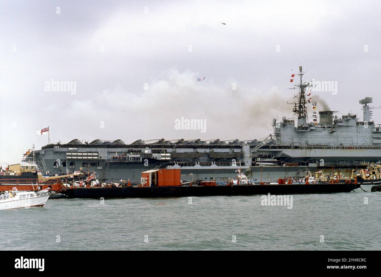 Circondata da barche, la HMS Hermes torna dalle Falklands al porto di Portsmouth Foto Stock