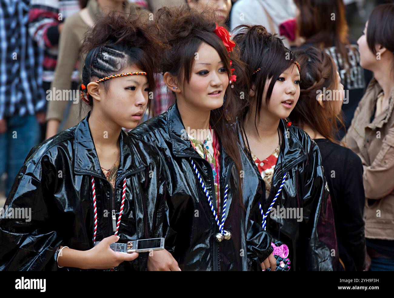 Tre ragazze adolescenti giapponesi vestite allo stesso modo con giacche nere lucide e acconciature in stile punk con accessori coordinati. Foto Stock