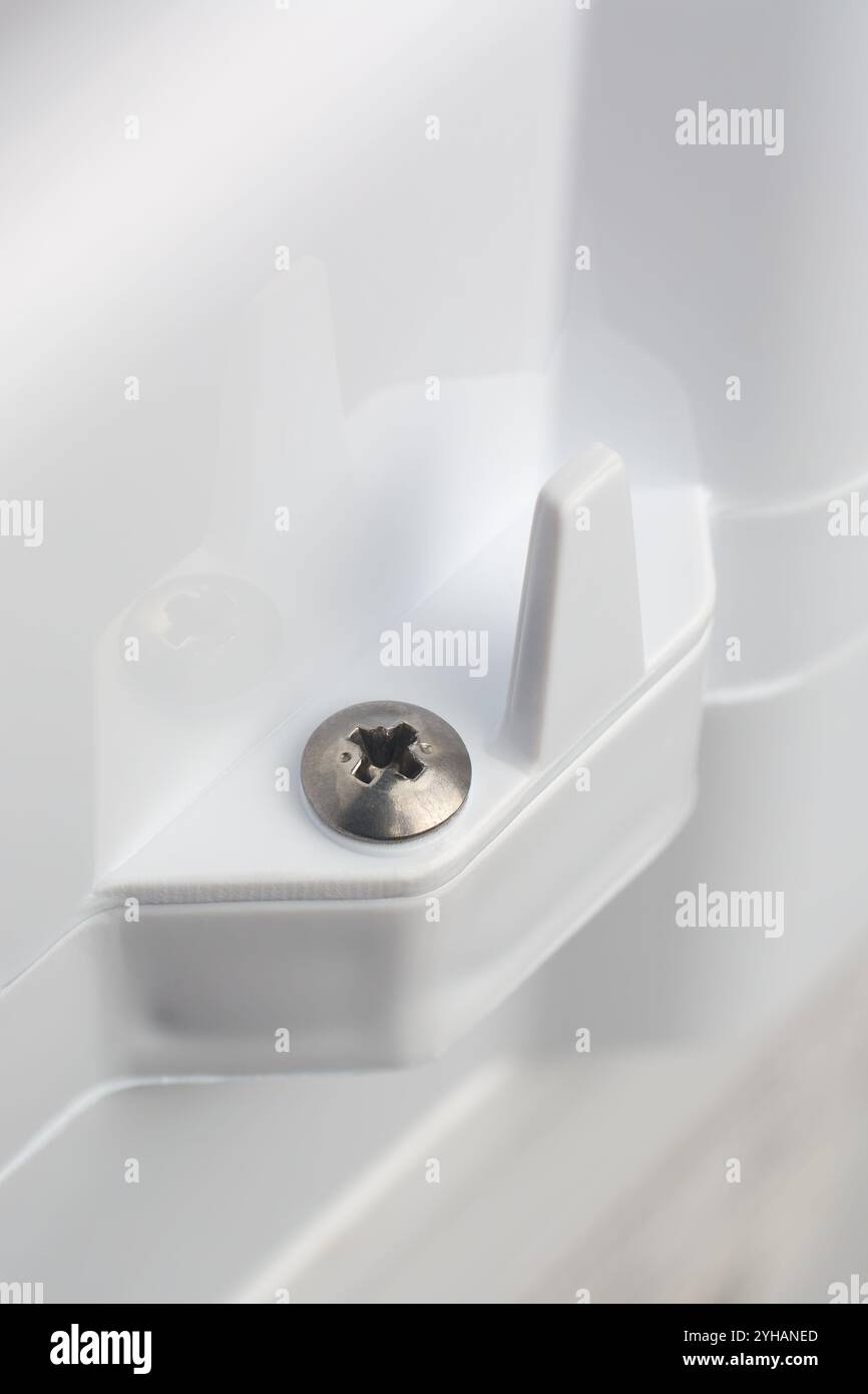 primo piano della testa a croce phillips montata su un prodotto in plastica testurizzata bianca o su una superficie dell'apparecchio, messa a fuoco morbida con spazio di copia Foto Stock