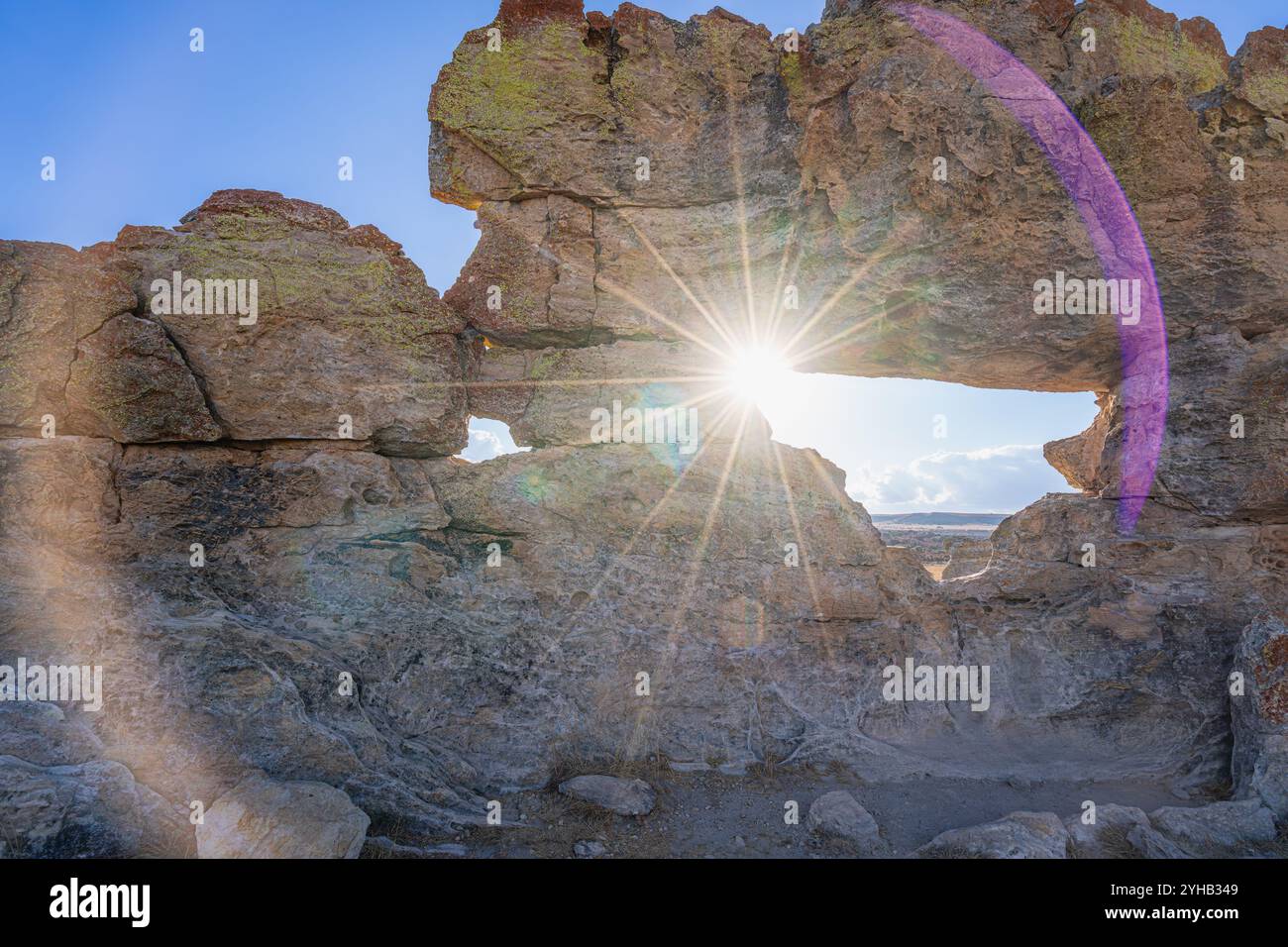 Spettacolari scoppi di sole che penetrano attraverso la formazione rocciosa naturale con motivi di licheni multicolori. Famoso punto panoramico della finestra del tramonto presso l'Isalo National Park Foto Stock