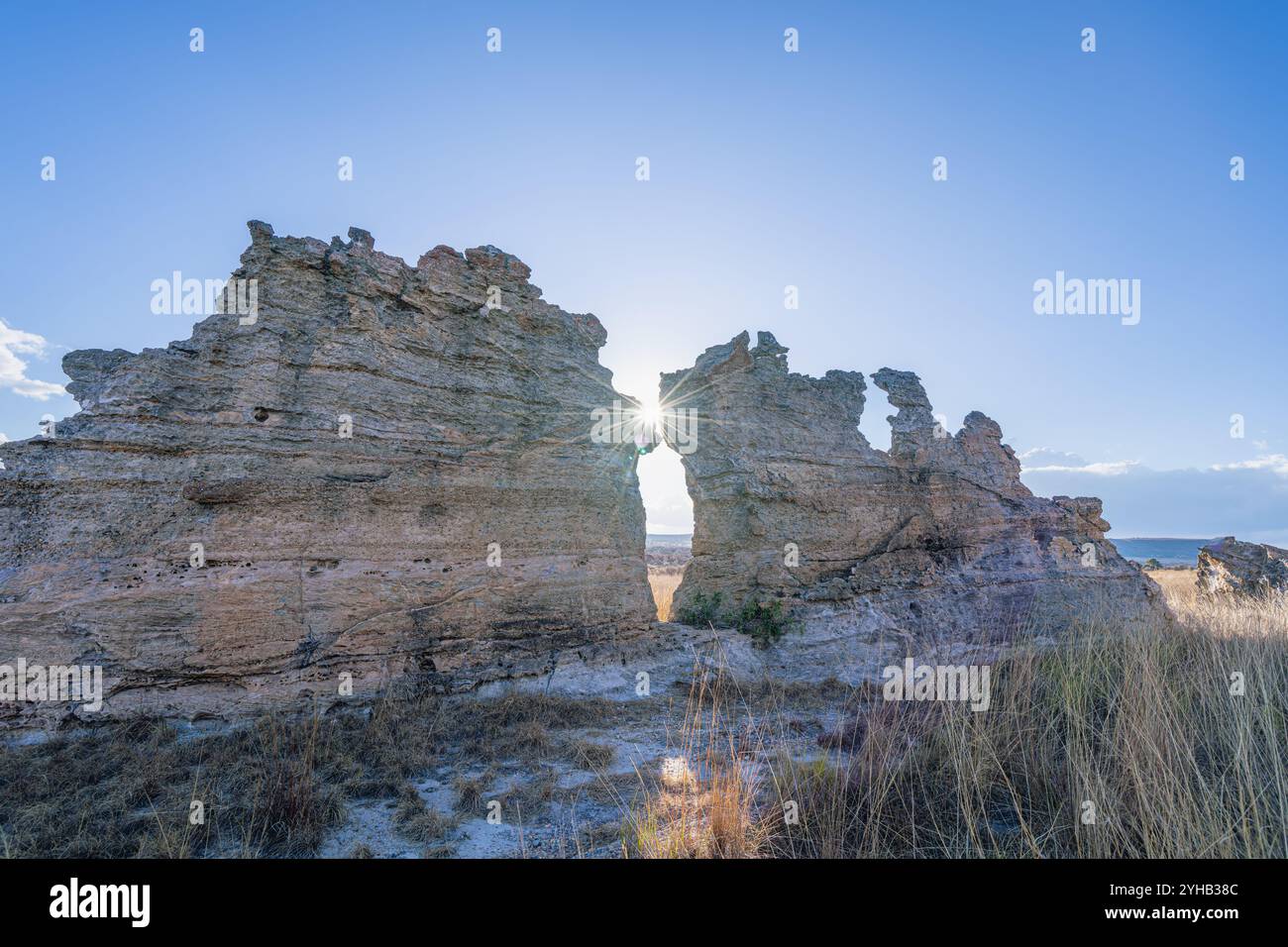 Spettacolari scoppi di sole che penetrano attraverso la formazione rocciosa naturale con motivi di licheni multicolori. Famoso punto panoramico della finestra del tramonto presso l'Isalo National Park Foto Stock