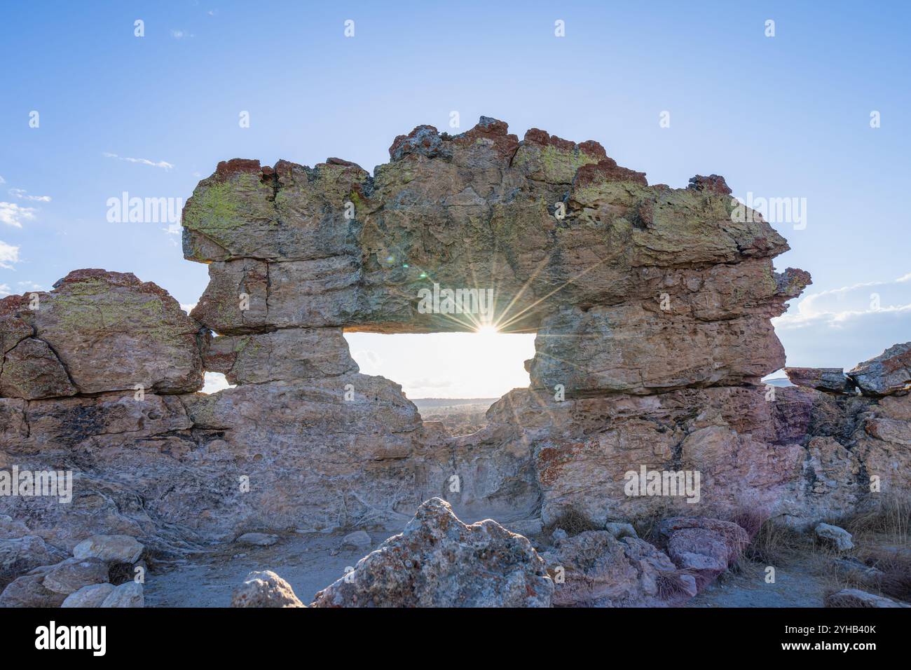 Spettacolari scoppi di sole che penetrano attraverso la formazione rocciosa naturale con motivi di licheni multicolori. Famoso punto panoramico della finestra del tramonto presso l'Isalo National Park Foto Stock