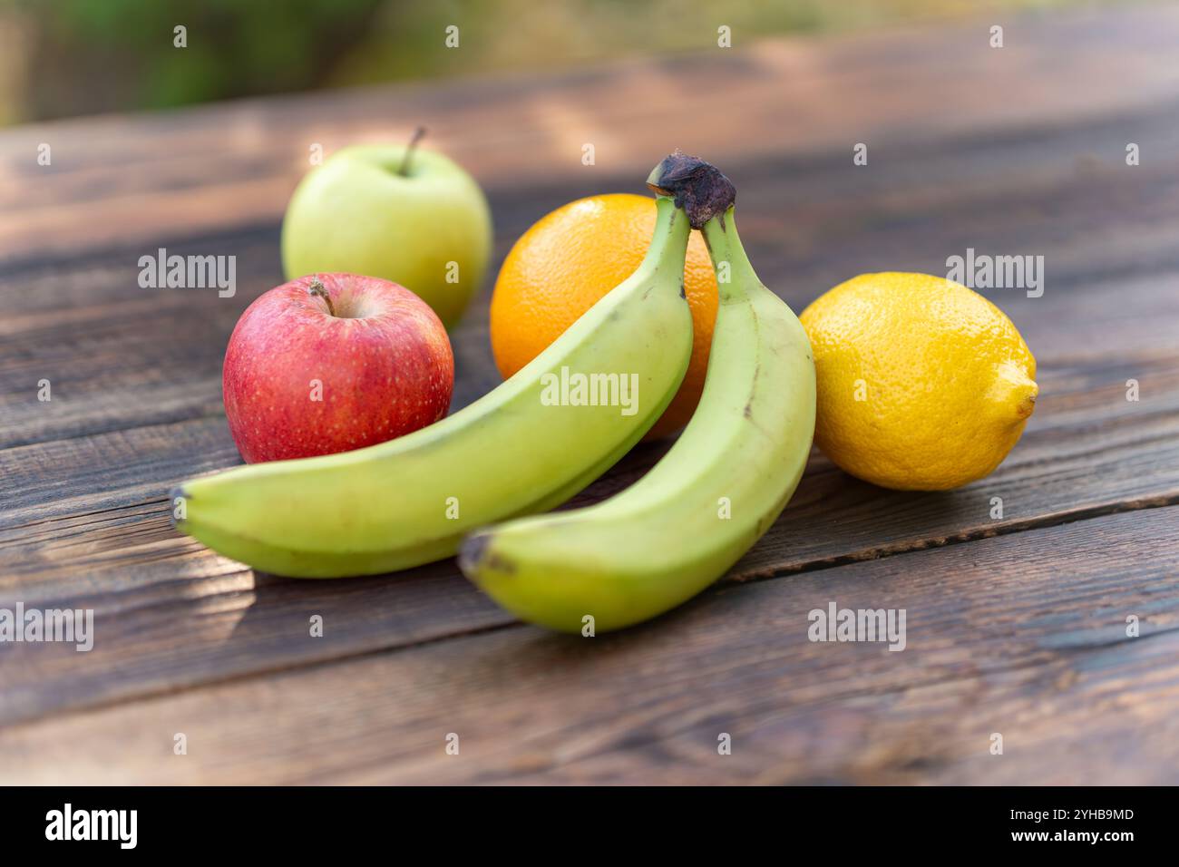arance, banane, pino, mele e limoni su tavola di legno Foto Stock