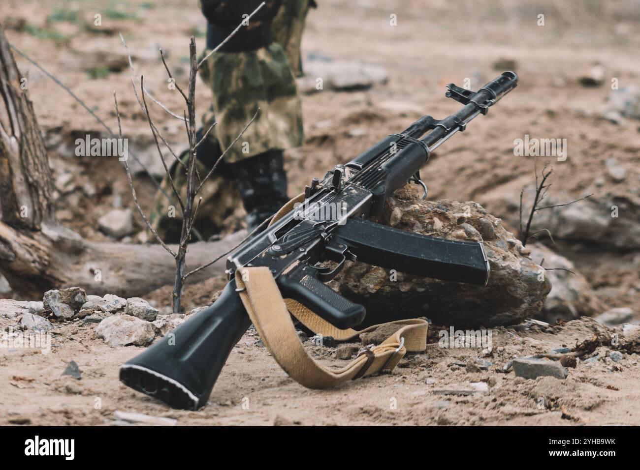 Un fucile d'assalto Kalashnikov è a terra. Il concetto di guerra Foto Stock