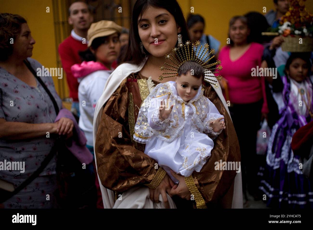 Un adolescente vestito da Vergine del Carmelo tiene un Gesù bambino durante il quartiere Calenda di Carmen Bajo a Oaxaca, in Messico. Foto Stock