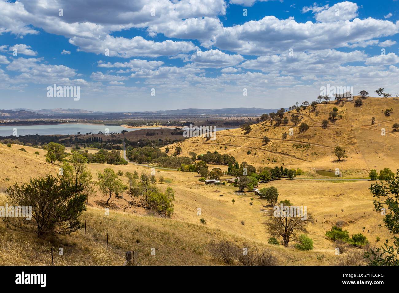 Splendida vista dal Kurrajong Gap Lookout con colline dorate, alberi e prati e sereni corsi d'acqua sotto un cielo nuvoloso, Victoria, Australia Foto Stock