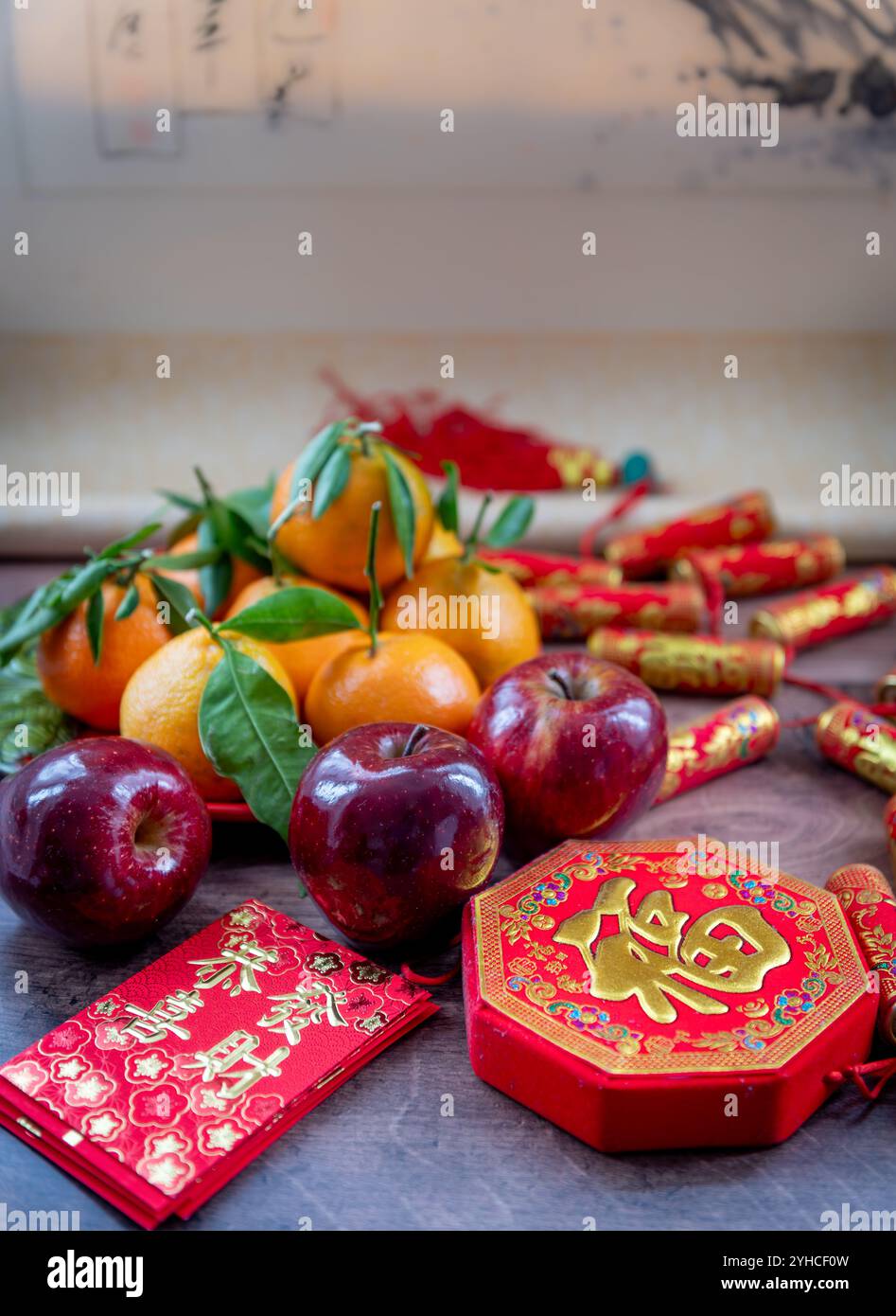 Mandarini e mele rosse. Decorazioni di Capodanno lunare e pacchetti rossi con buona fortuna, salute, ricchezza parole su di loro. Un background cinese per il Capodanno, Foto Stock