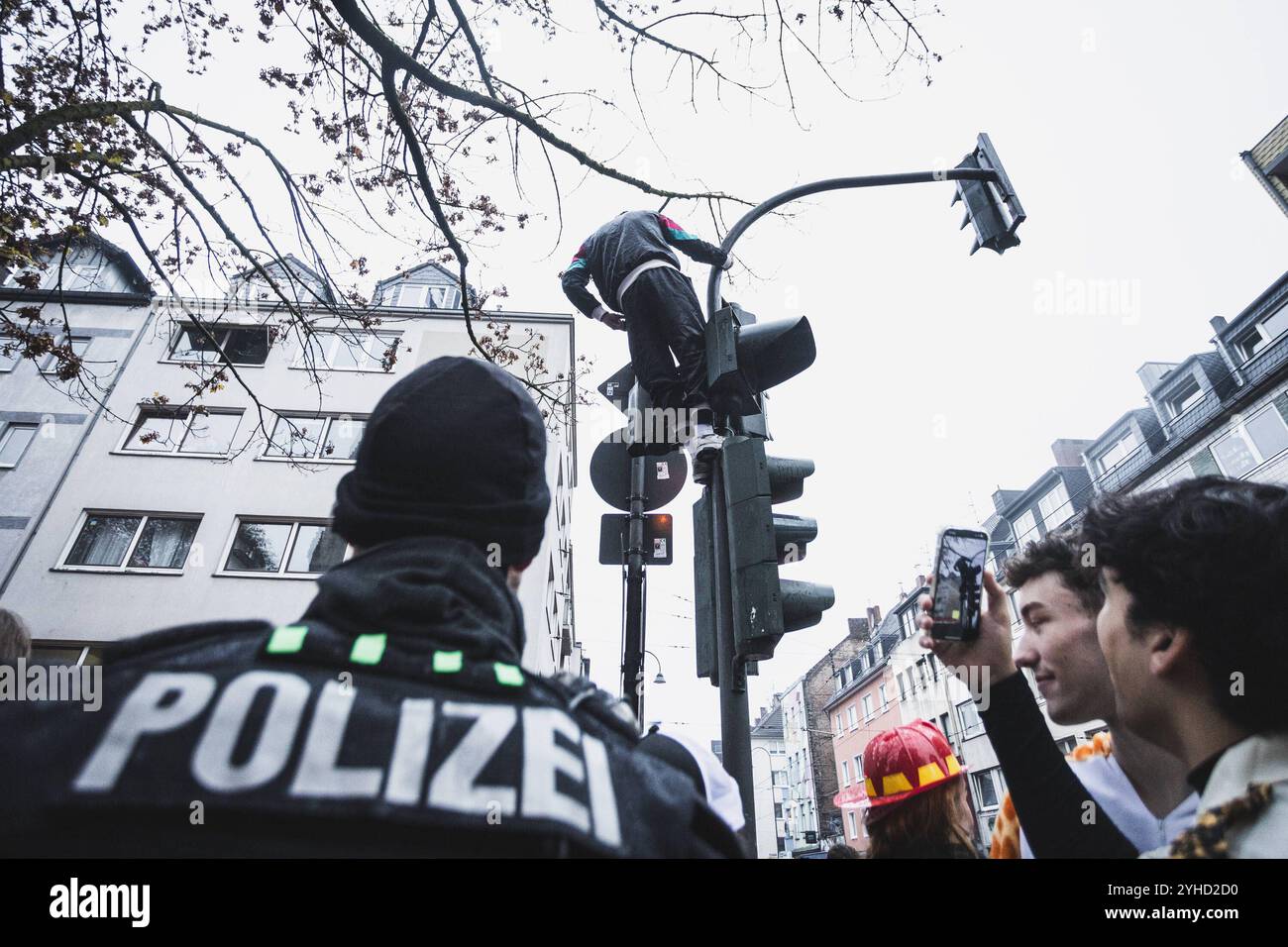 Zülpicher Strasse, Köln Karneval 11.11., ein Mann auf dem Ampel, Polizisten stehen daneben Zülpicher Strasse, Köln Karneval 11.11.2024 Köln Innenstadt NRW Deutschland *** Zülpicher Strasse, Cologne Carnival 11 11 11 , un uomo al semaforo, poliziotti in piedi accanto ad esso Zülpicher Strasse, Cologne Carnival 11 2024 Cologne City Centre NRW Germania Copyright: XBEAUTIFULXSPORTS/BuriovakSPORTS Foto Stock