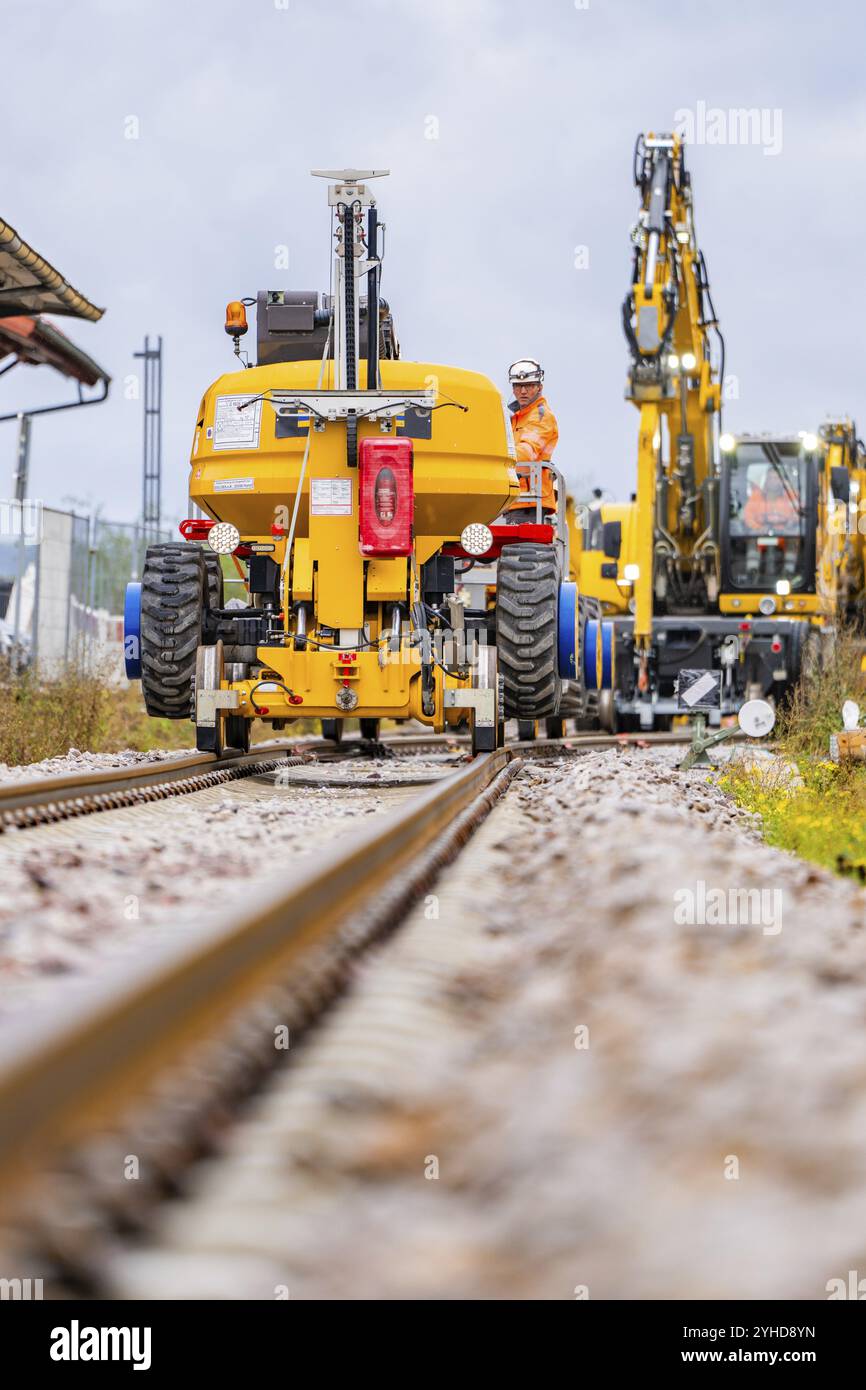 I lavoratori edili gestiscono macchine gialle lungo i binari di un cantiere, costruzione di binari Hermann Hesse Railway, distretto di Calw, Black F. Foto Stock