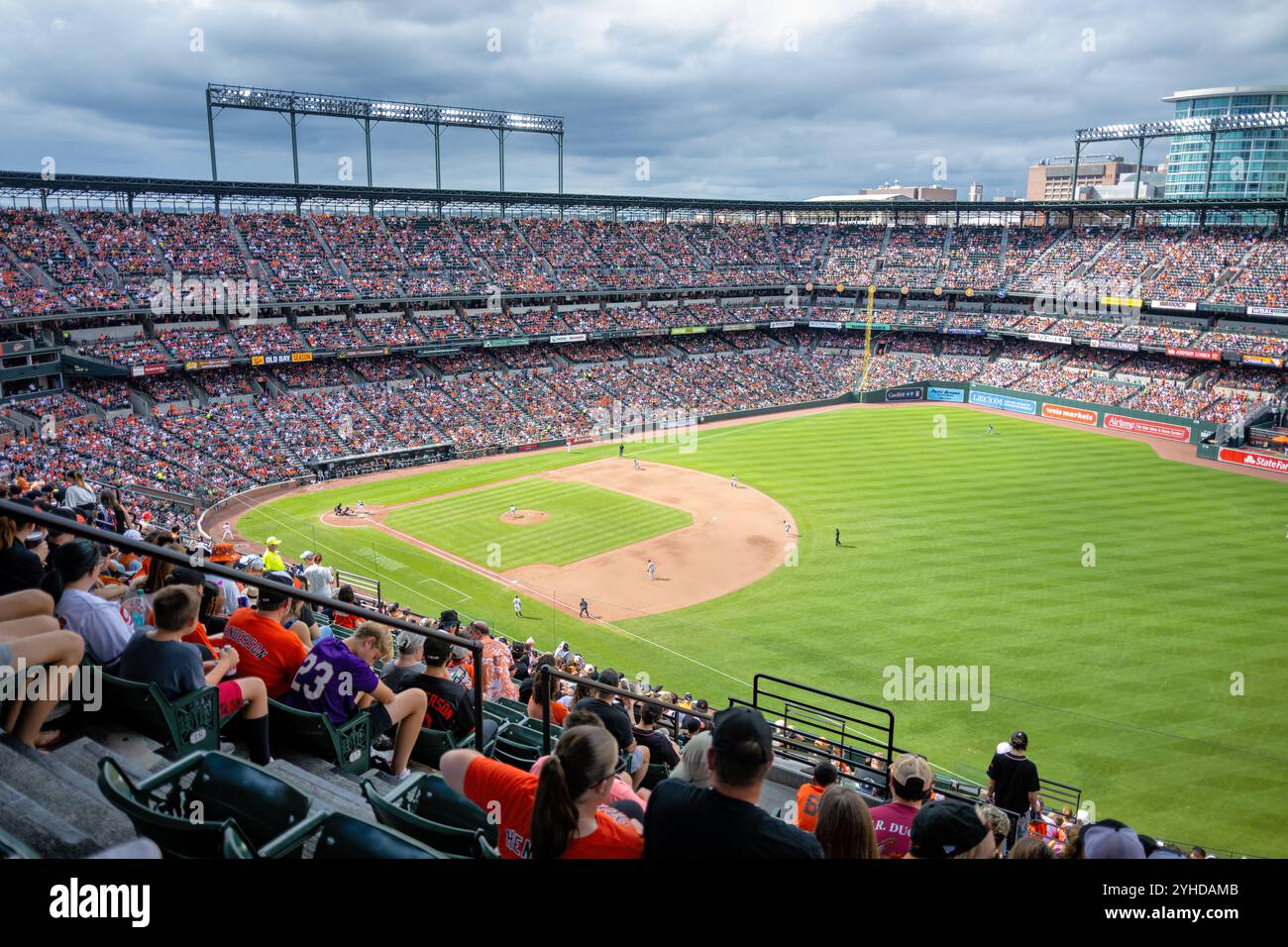 Oriole Park at Camden Yards Baseball Game Baltimore Maryland // BALTIMORE, Maryland - Una partita di baseball si svolge all'Oriole Park at Camden Yards, sede dei Baltimore Orioles. Lo stadio, aperto nel 1992, ha stabilito lo standard per il design retrò-classico del campo da baseball nella Major League Baseball. Il caratteristico B&o Warehouse del campo da baseball fa da sfondo. Foto Stock